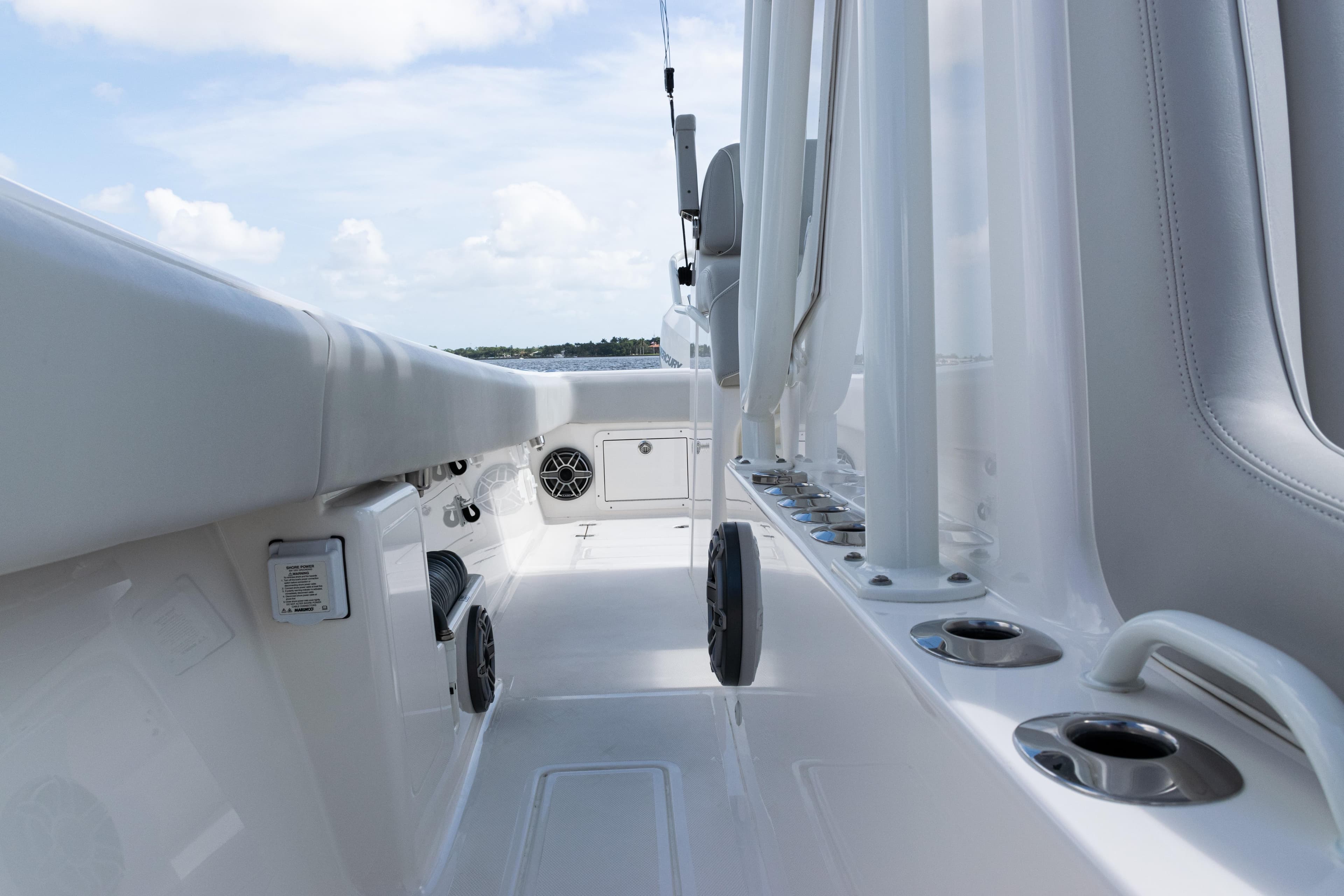 2024 SeaVee 290B boat deck with rod holders and seating, under a clear sky.