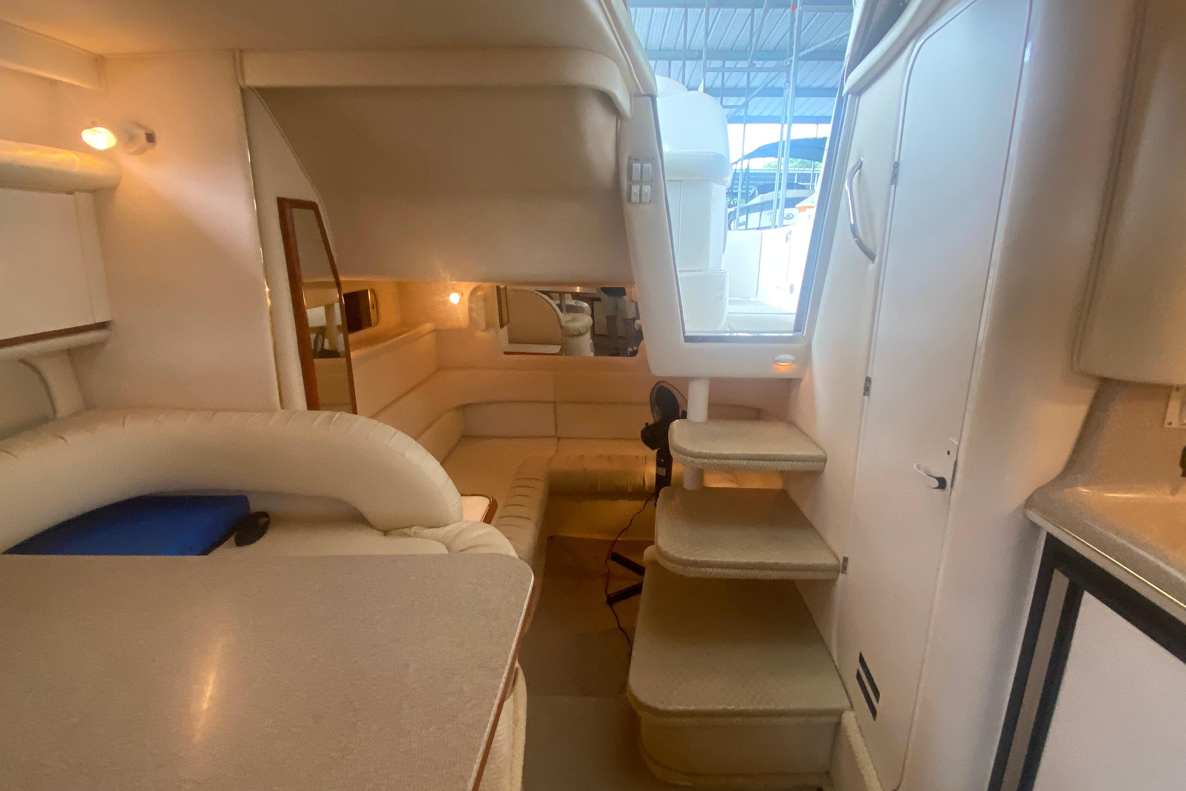Interior of 2001 Sea Ray 340 Sundancer yacht, featuring cozy seating and elegant design.