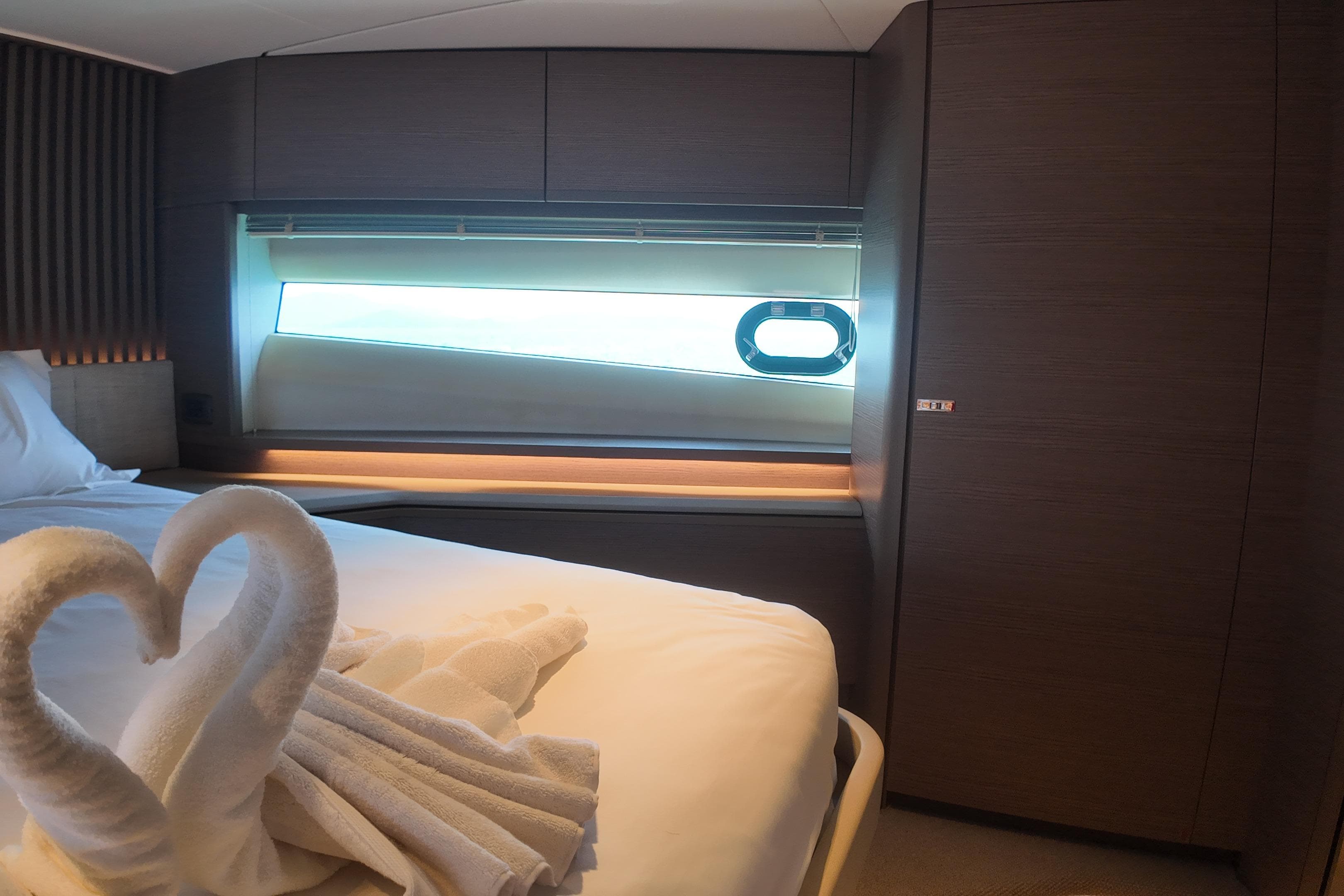 Luxurious cabin interior of 2023 Princess Y72 yacht with elegant bedding and window view.