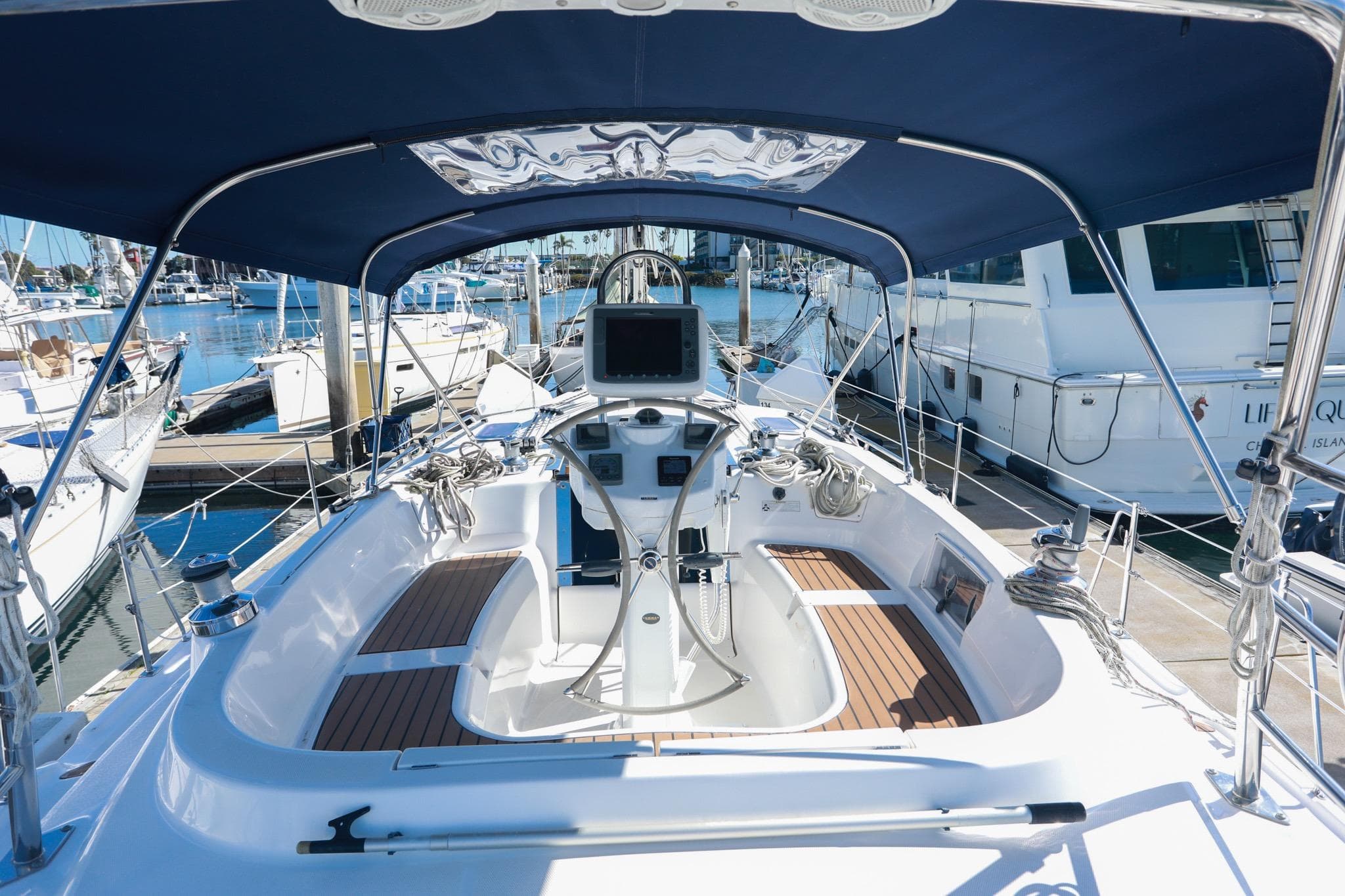 2009 Hunter 45 Center Cockpit sailboat with modern helm, docked in marina.