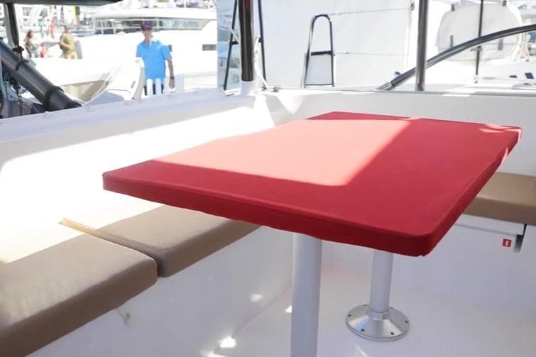 Interior of 2019 Outremer 4X catamaran with red table and beige seating.