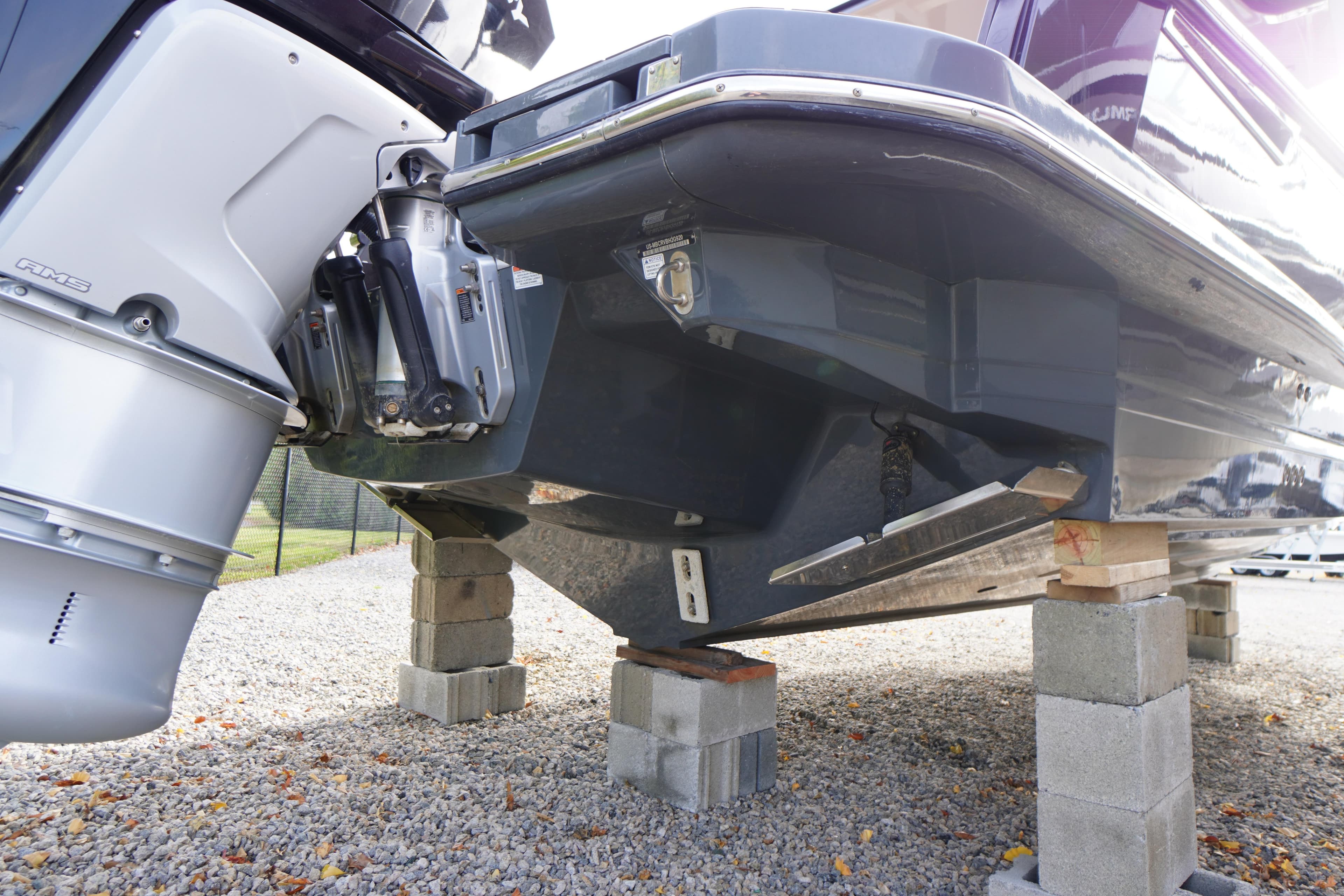 2020 Aviara AV32 OB boat on blocks, showcasing outboard motor and hull design.