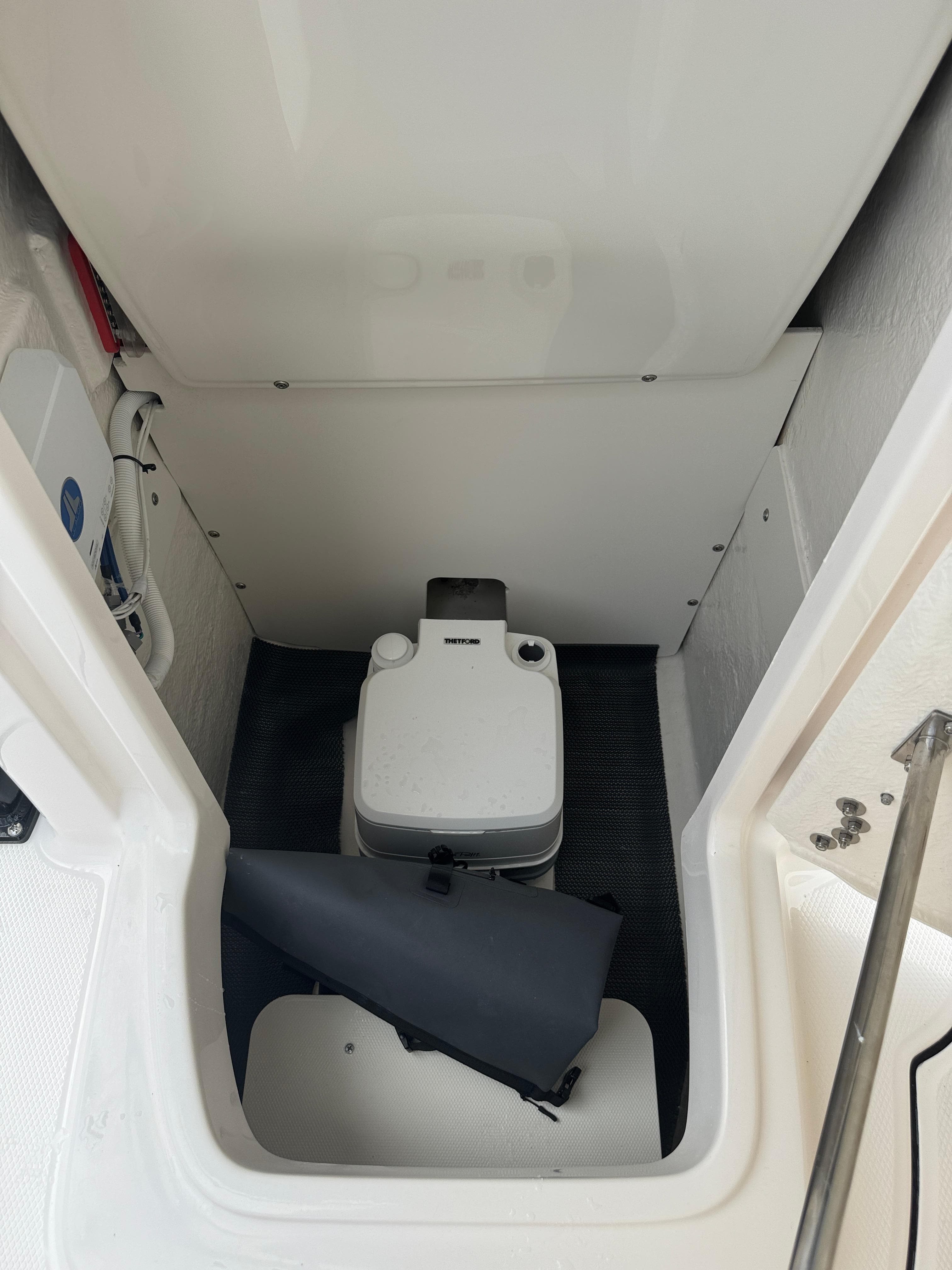 2025 Robalo R222 Center Console boat interior with compact toilet setup.