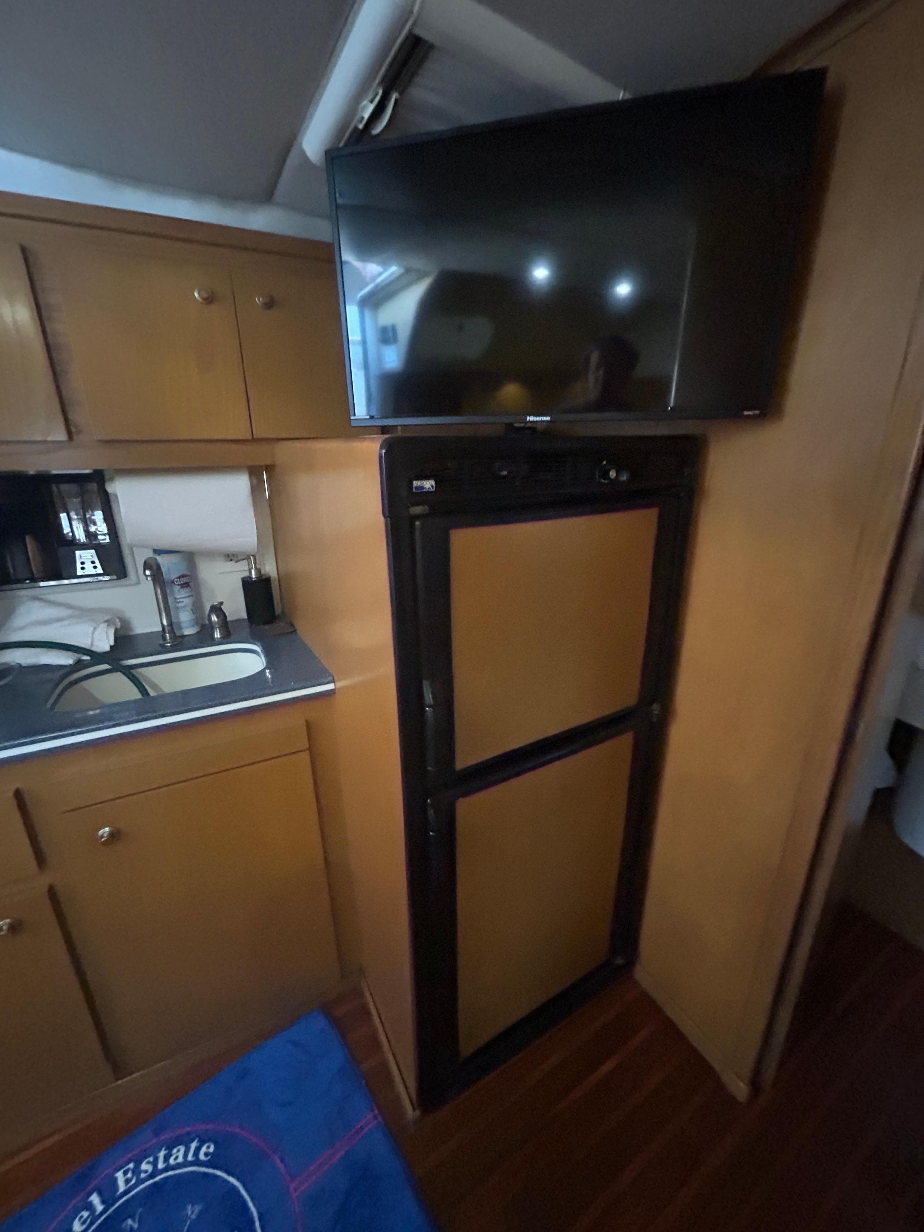 1998 Tiara Yachts 3500 Express interior with kitchenette, fridge, and mounted TV.