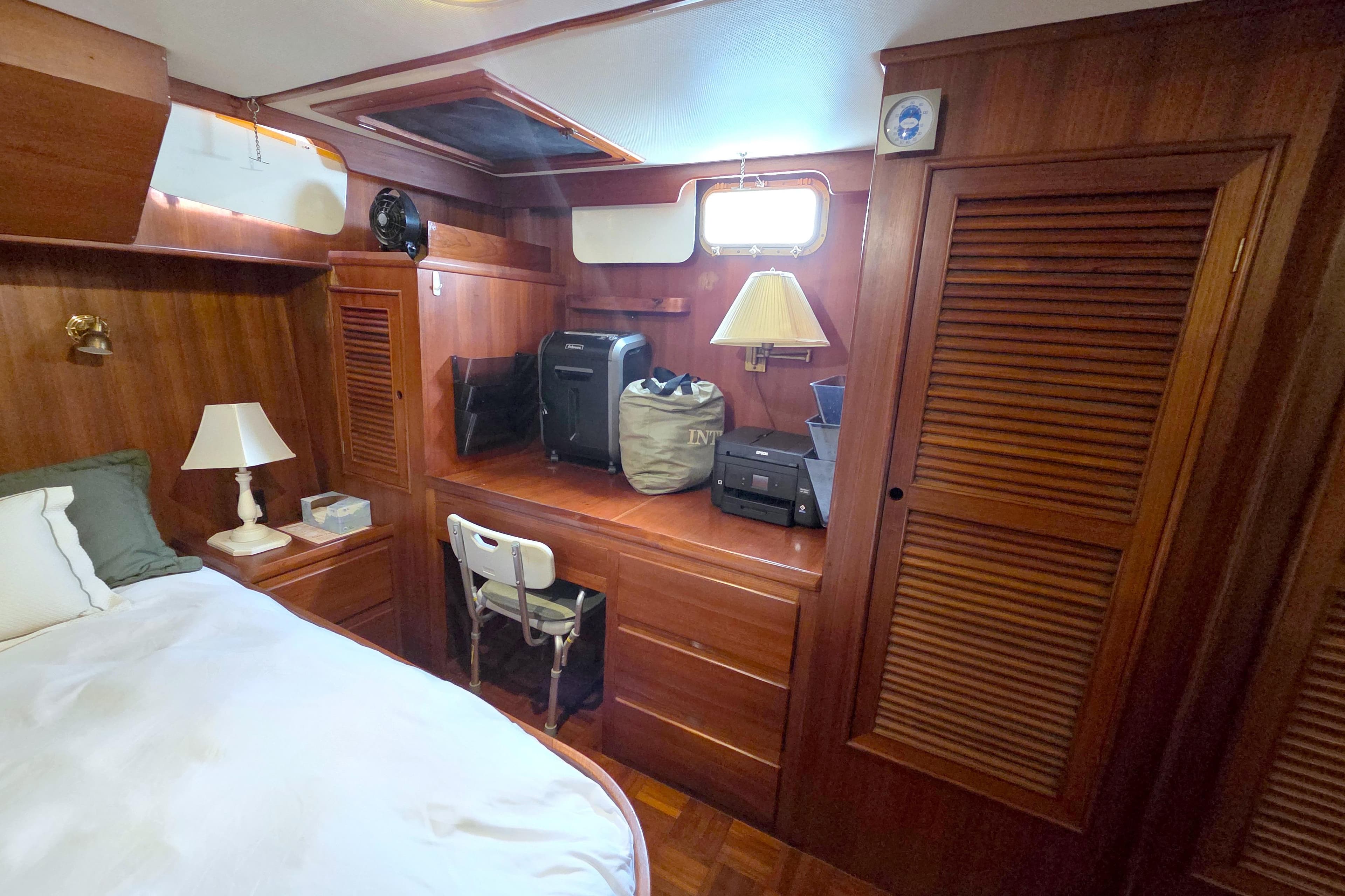 Cozy cabin interior of 1984 Present Yachts 42 Sundeck with wooden furnishings and bed.