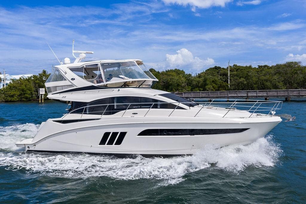2017 Sea Ray Fly 510 yacht cruising on blue water under a clear sky.