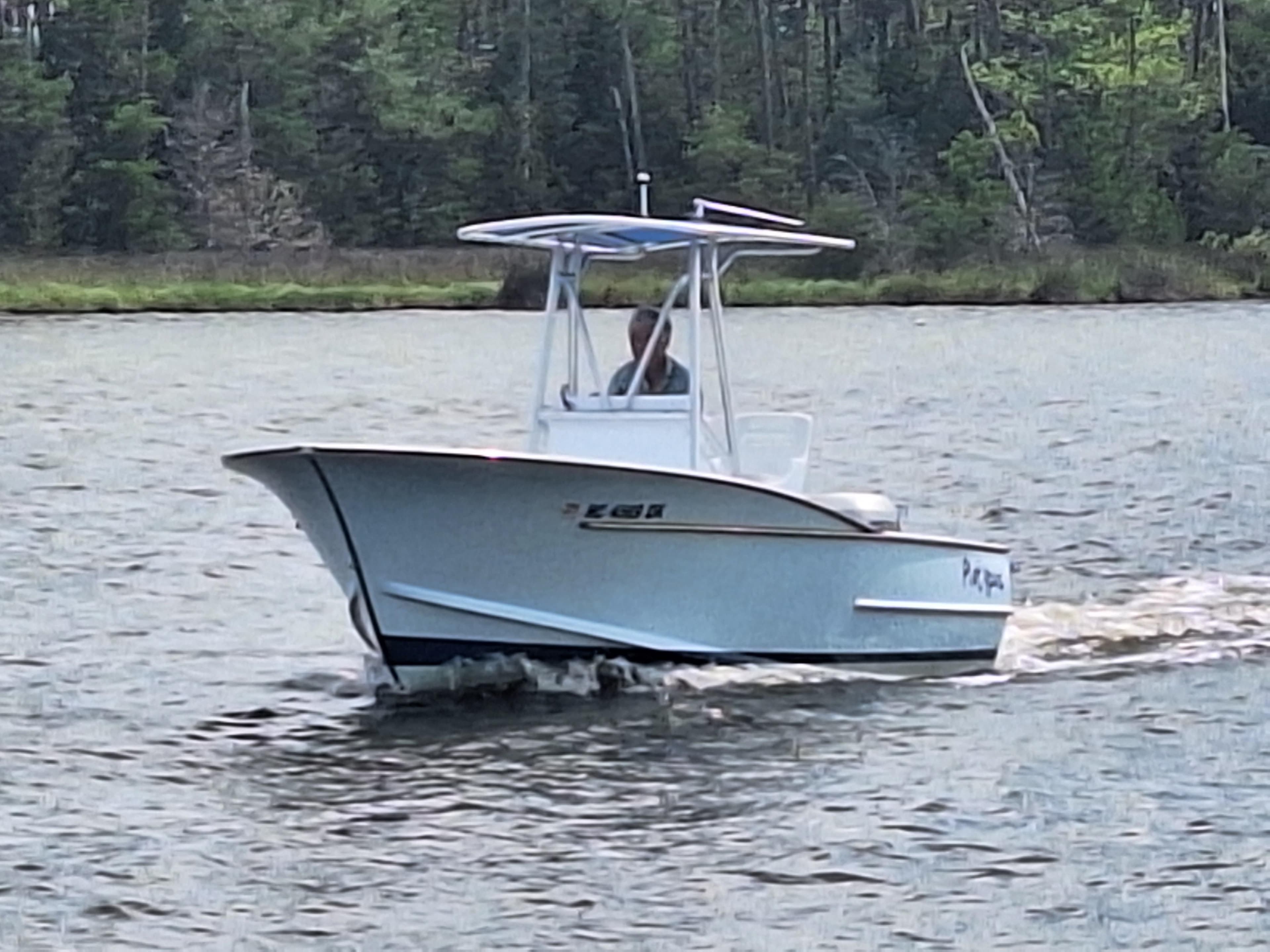 2008 Custom Carolina boat cruising on a calm river.