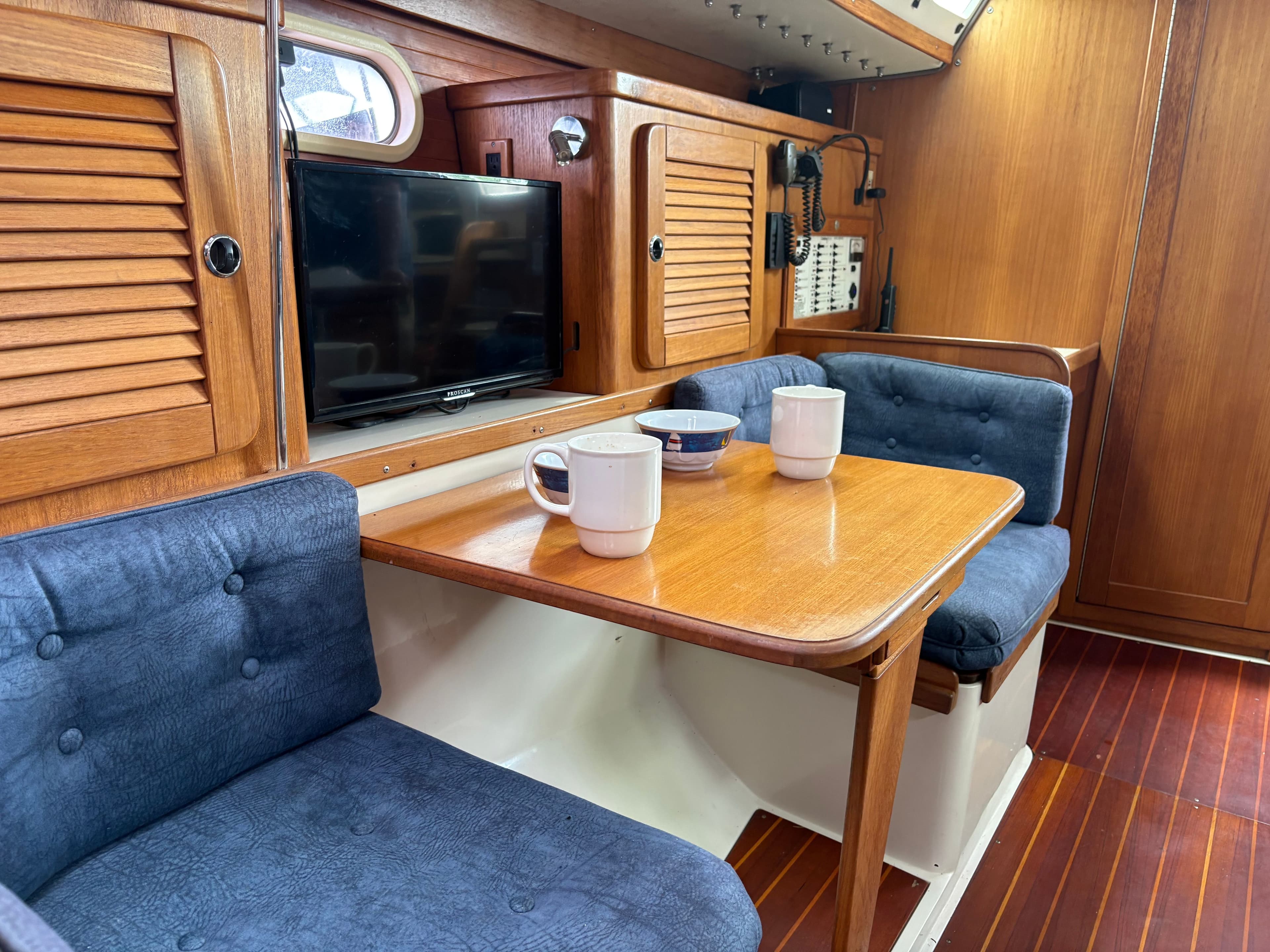 Interior of a 2000 Catalina 36 MkII yacht with wooden furniture and blue upholstery.