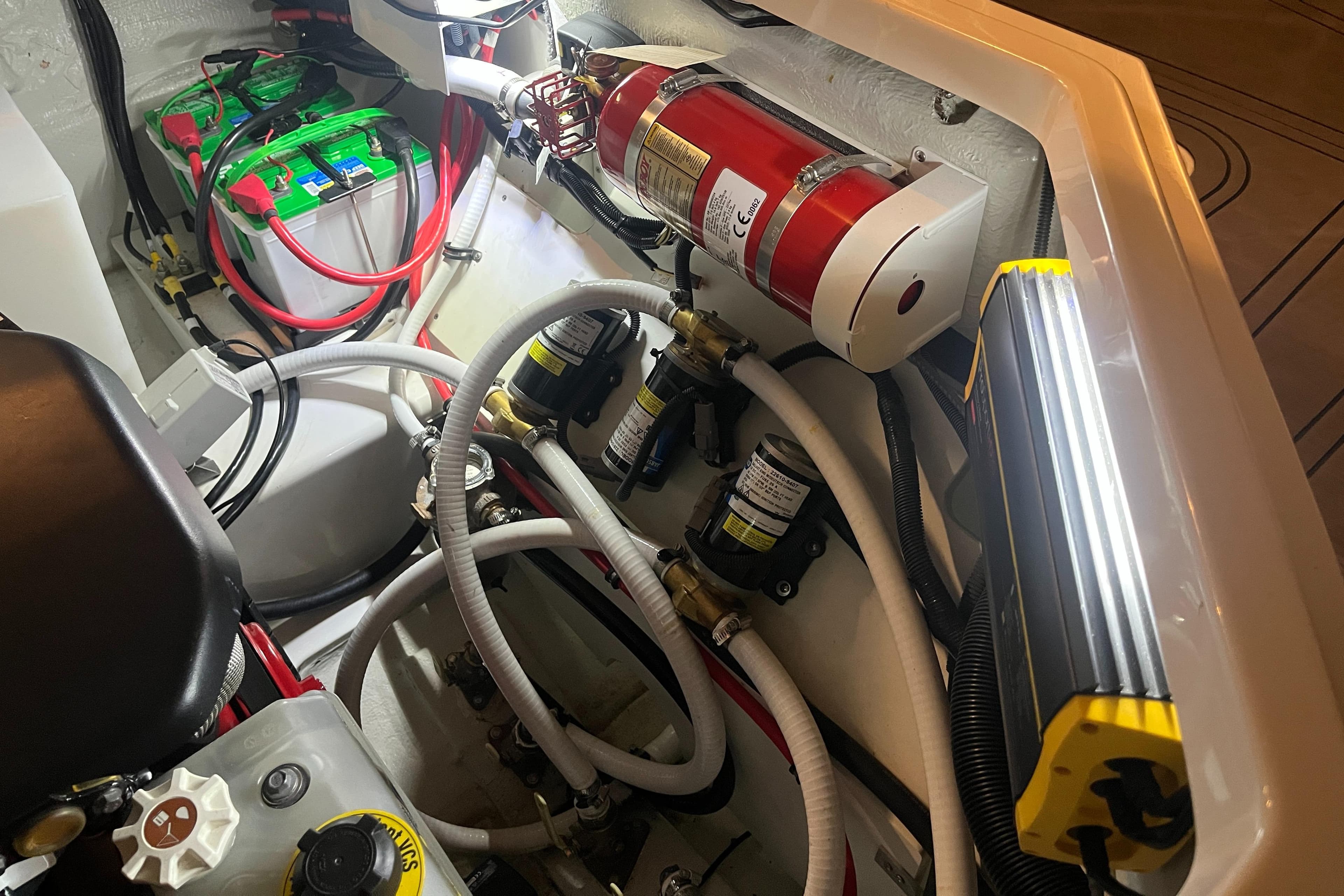 Engine compartment of 2021 Cobalt R8 Surf boat with fire extinguisher and wiring.