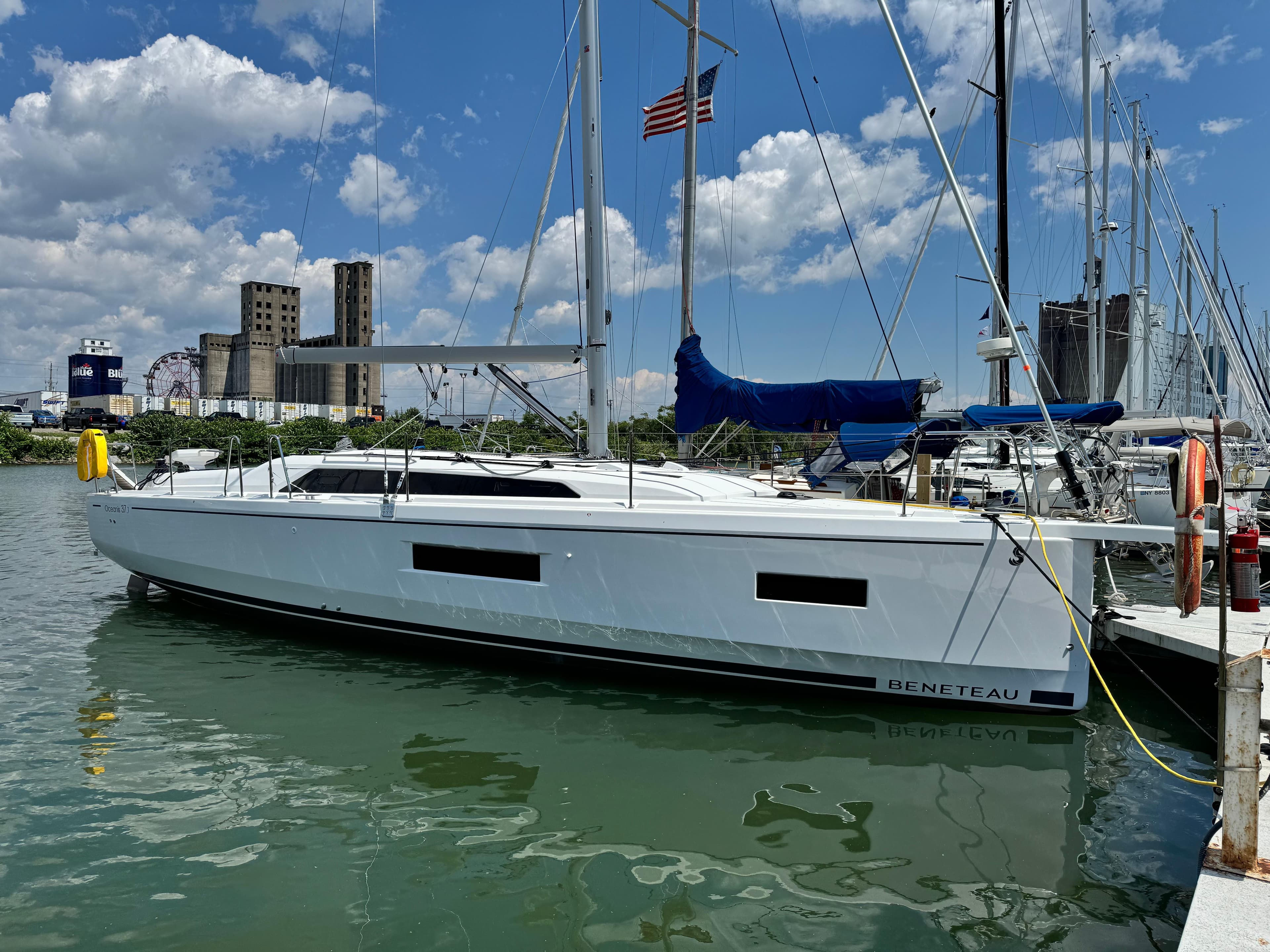 2024 Beneteau Oceanis 37.1 sailboat docked in a marina under a blue sky.