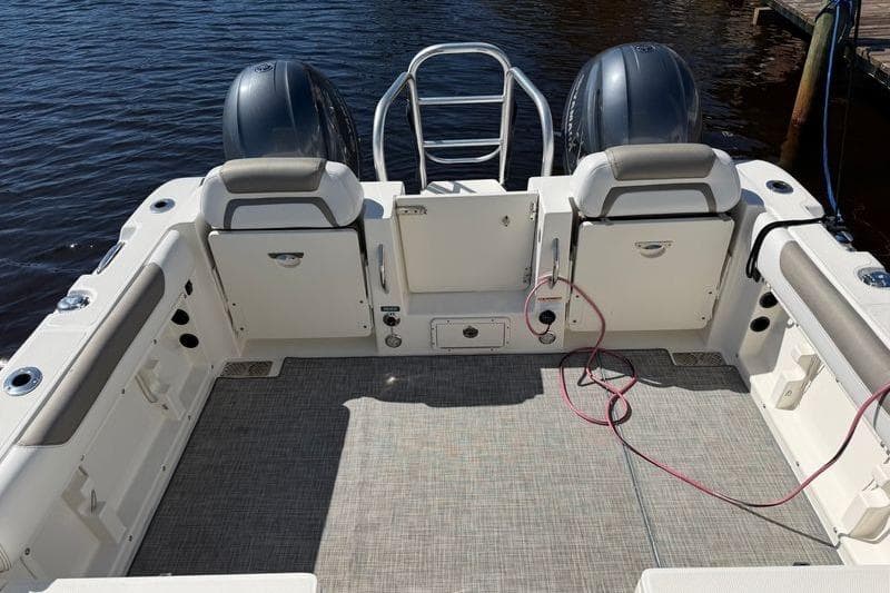 2019 World Cat 255 DC boat deck with dual engines and seating, docked on calm water.