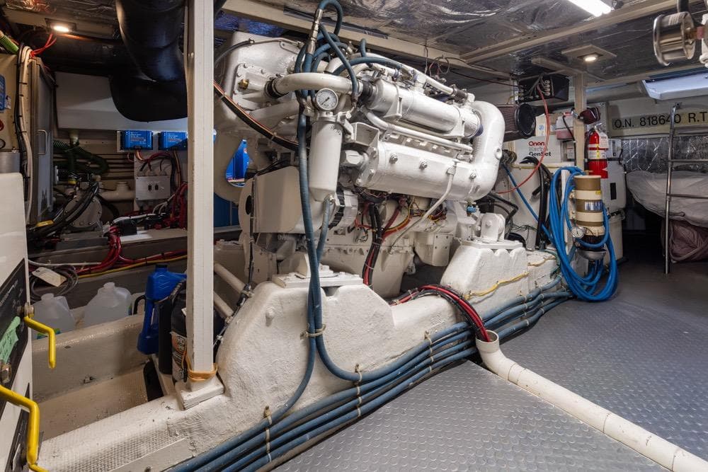 Engine room of a 1991 Tollycraft 57 Pilothouse Motor Yacht, showcasing machinery and equipment.