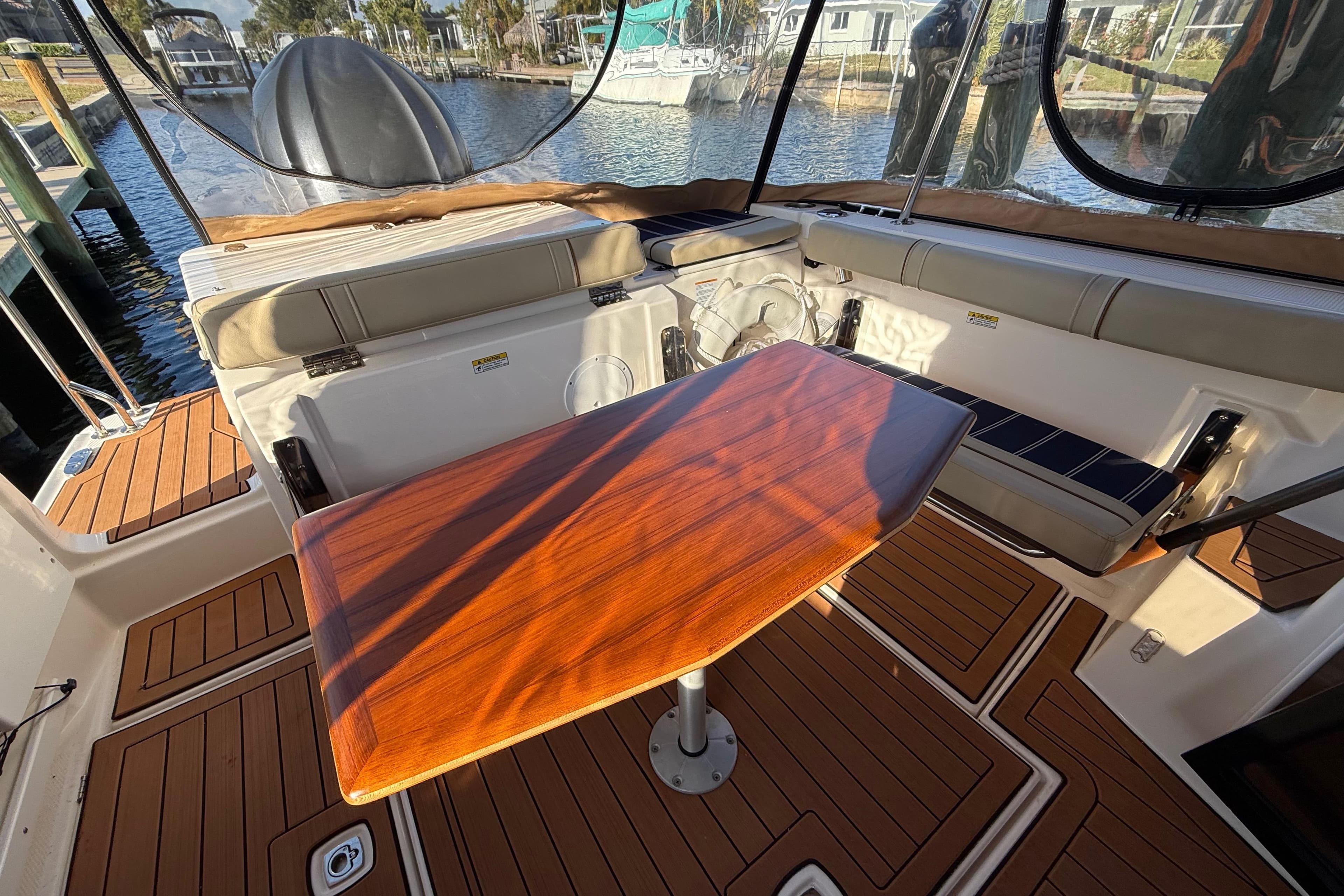 2022 Ranger Tugs R-27 boat interior with wooden table and cushioned seating.