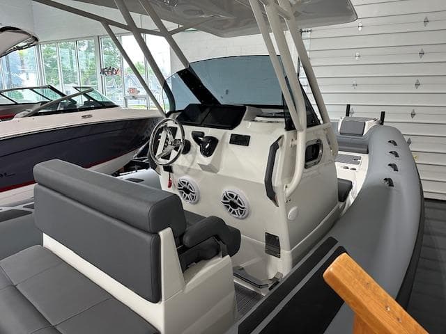 2025 Brig Eagle 8 boat interior with modern dashboard and seating in showroom.