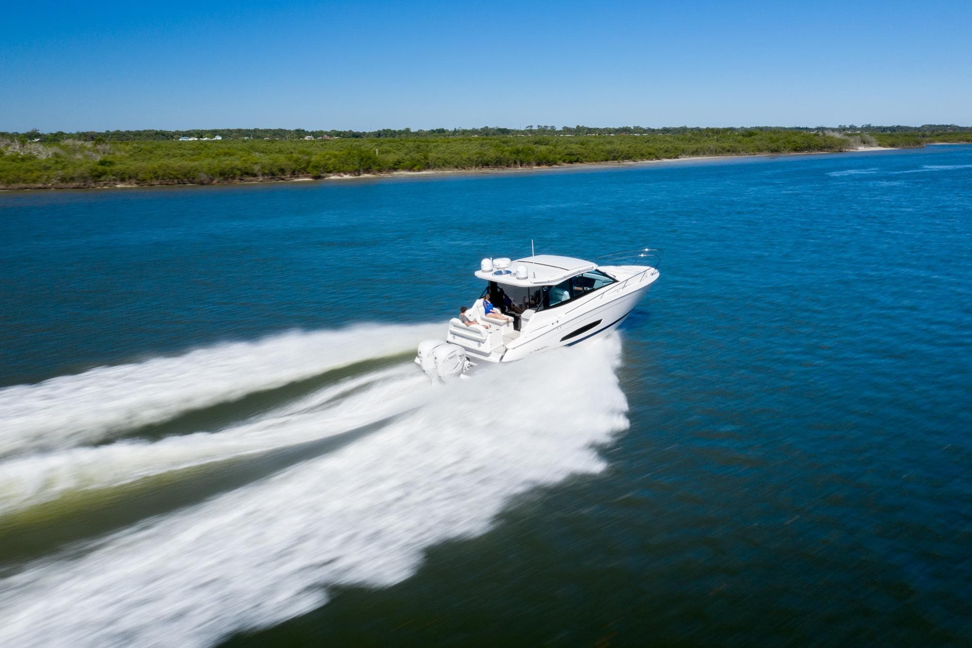 2026 Regal 36 XO boat cruising on a clear blue lake under a sunny sky.