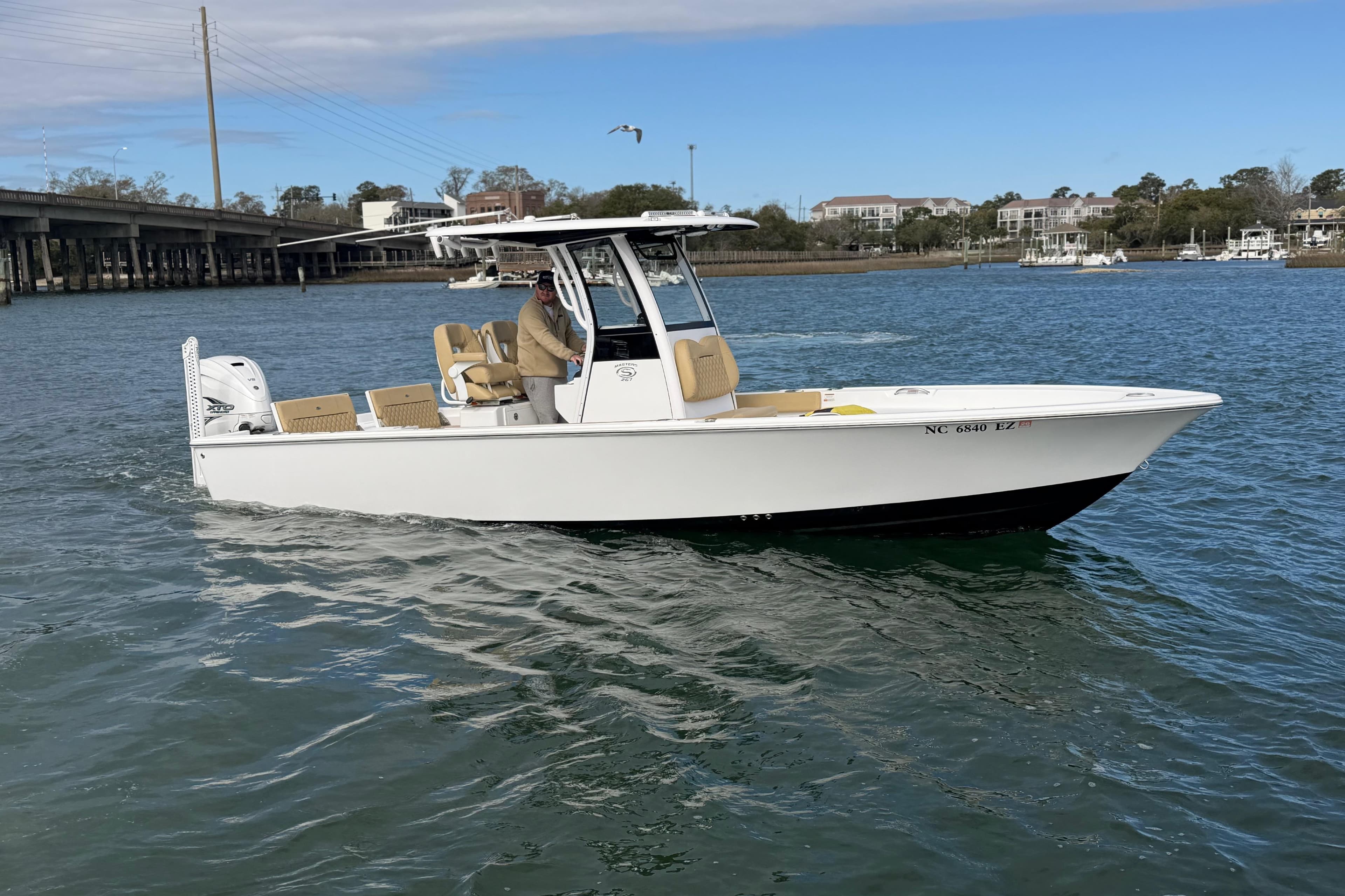 2023 Sportsman Masters 267 Bay Boat cruising on a scenic waterway.