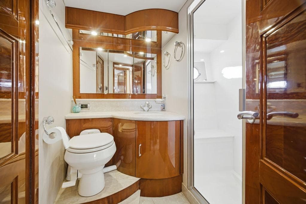 Luxurious 2006 Marquis 59 yacht bathroom with elegant wood finishes and modern fixtures.