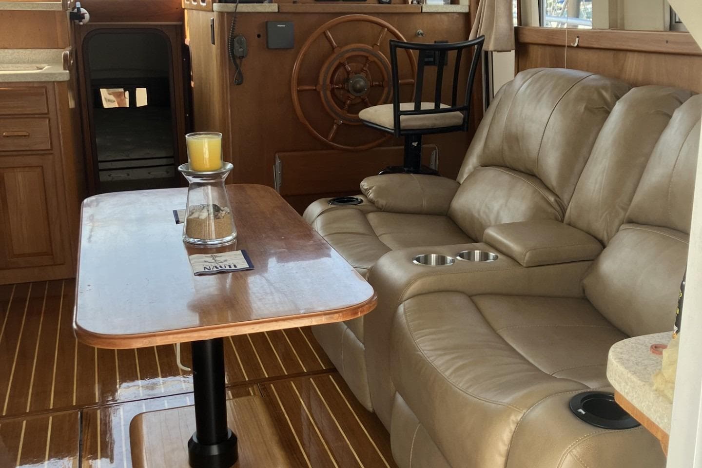 Interior of 1999 Mainship 350 Trawler with leather seating and wooden accents.