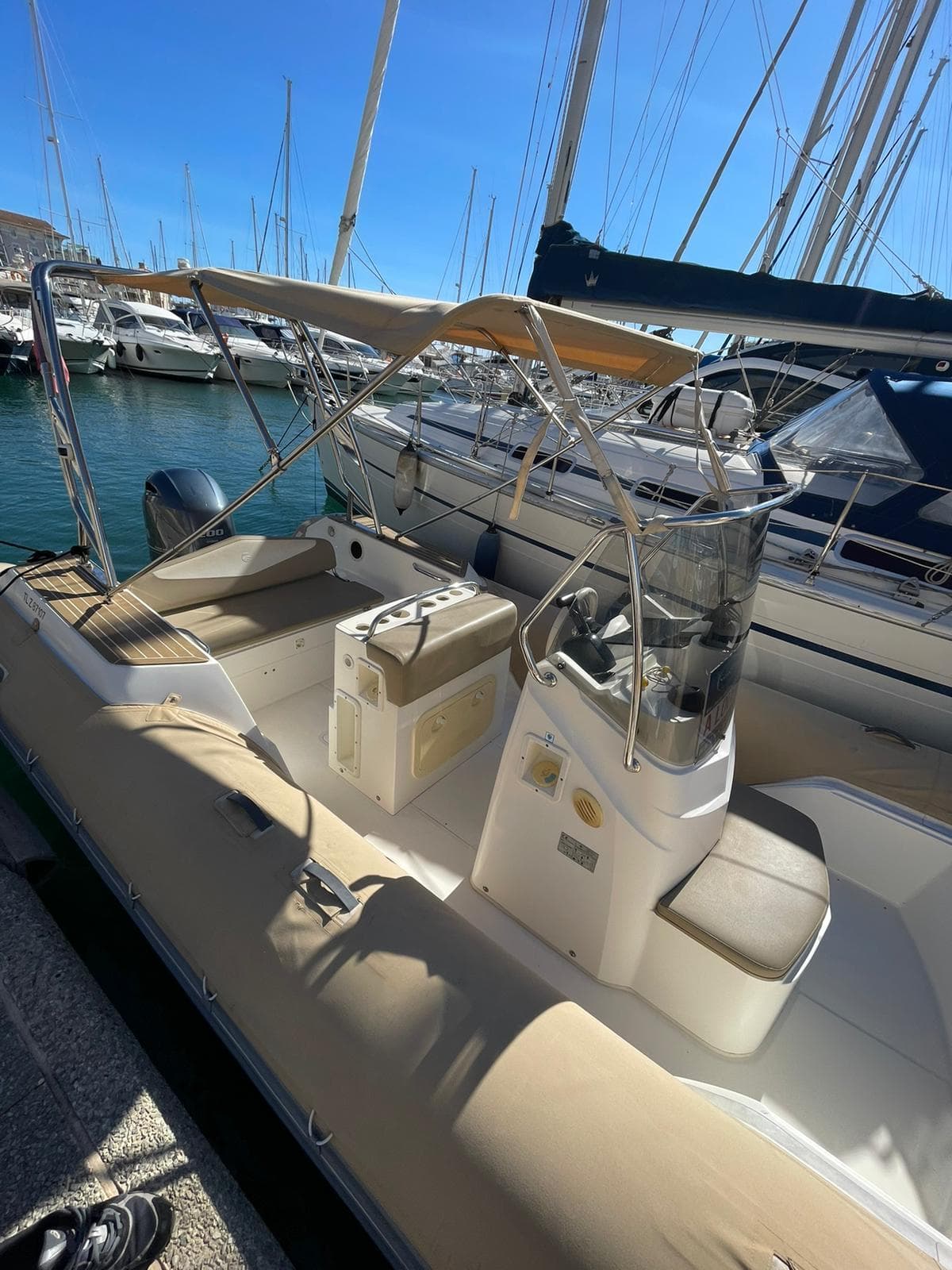 2019 Capelli Tempest 700 Open boat docked in marina, featuring spacious seating and canopy.
