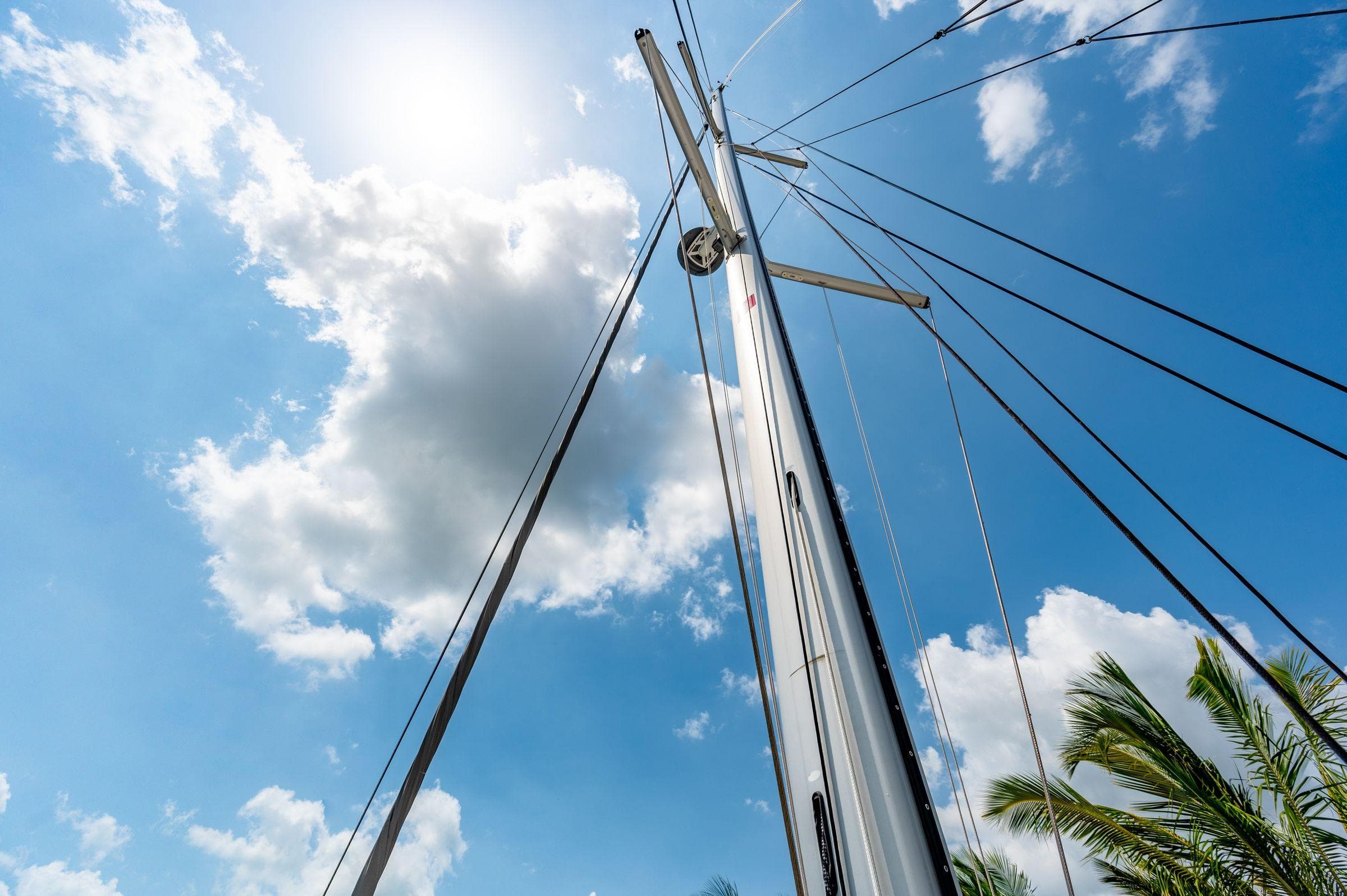Sailboat mast of 2021 Nautitech 46 Open against a sunny, cloudy sky.