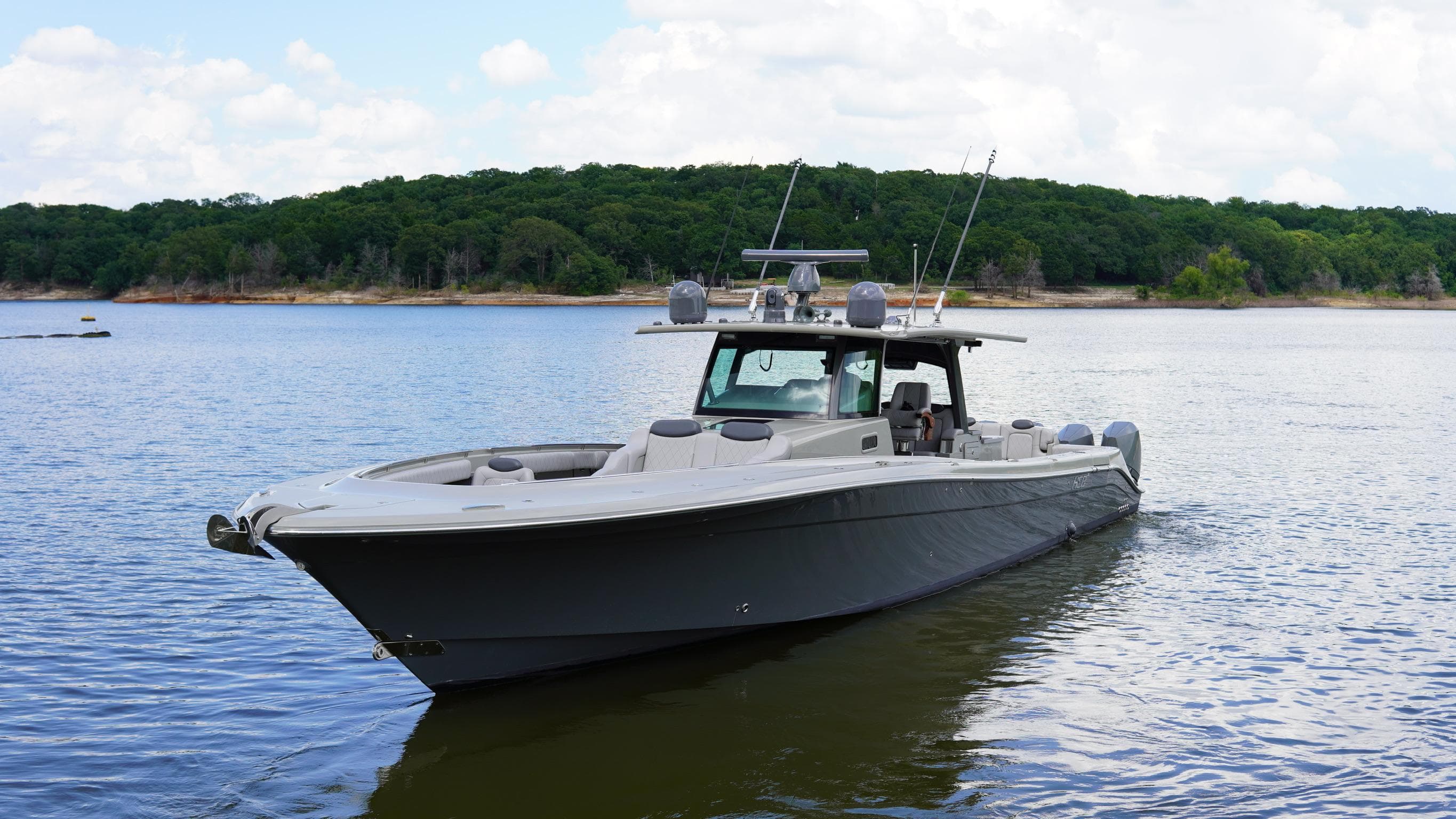 2021 HCB 53 boat on calm water with forested shoreline in background.
