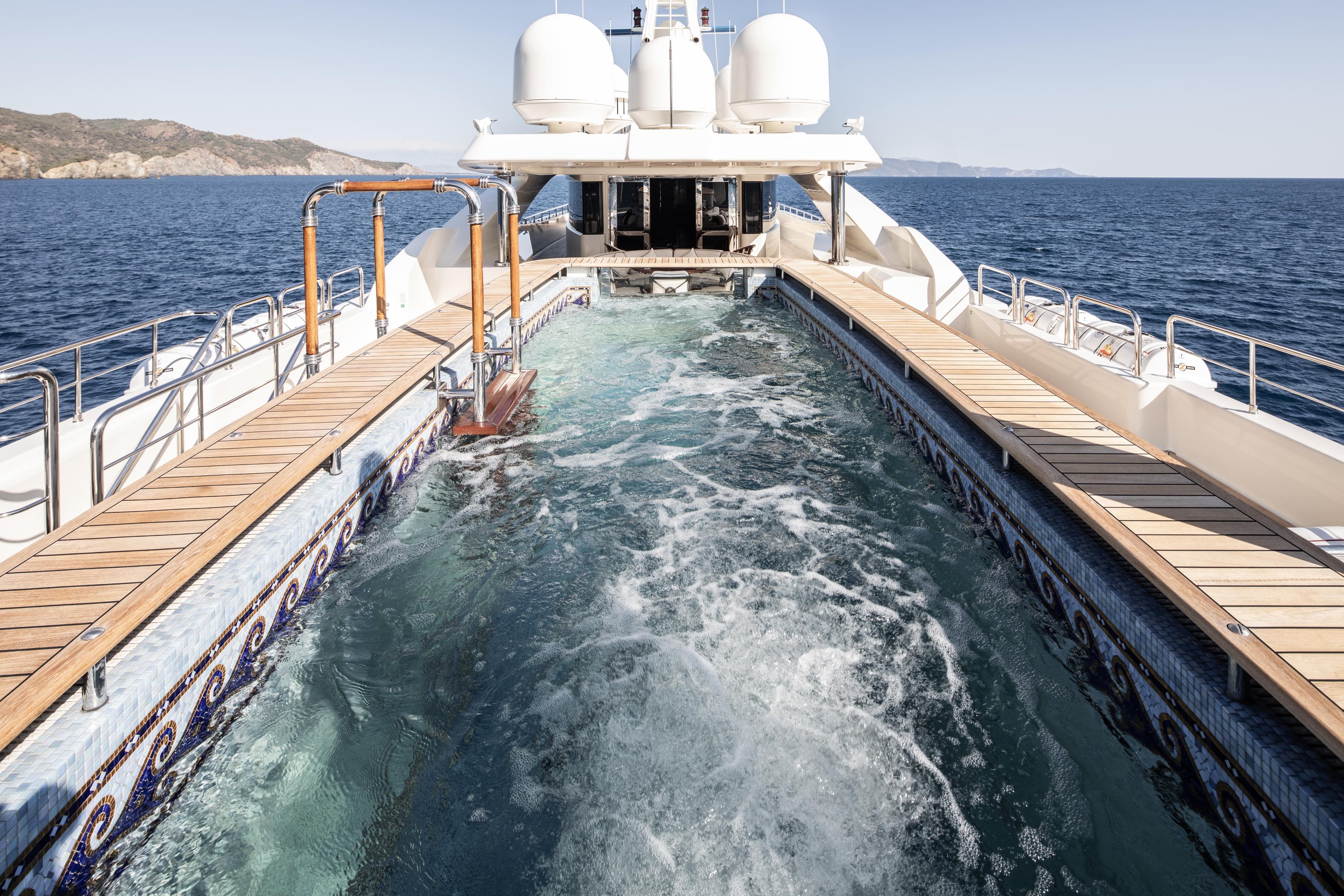 Luxurious 2008 CRN 185 yacht with onboard pool, cruising in open sea.