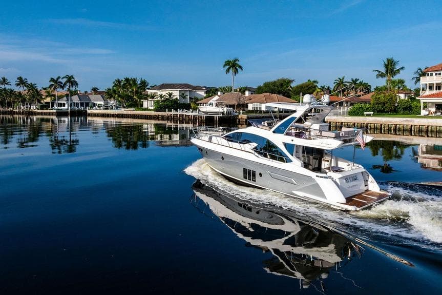 Luxurious 2015 Azimut Fly 50 yacht cruising in a serene waterfront setting.