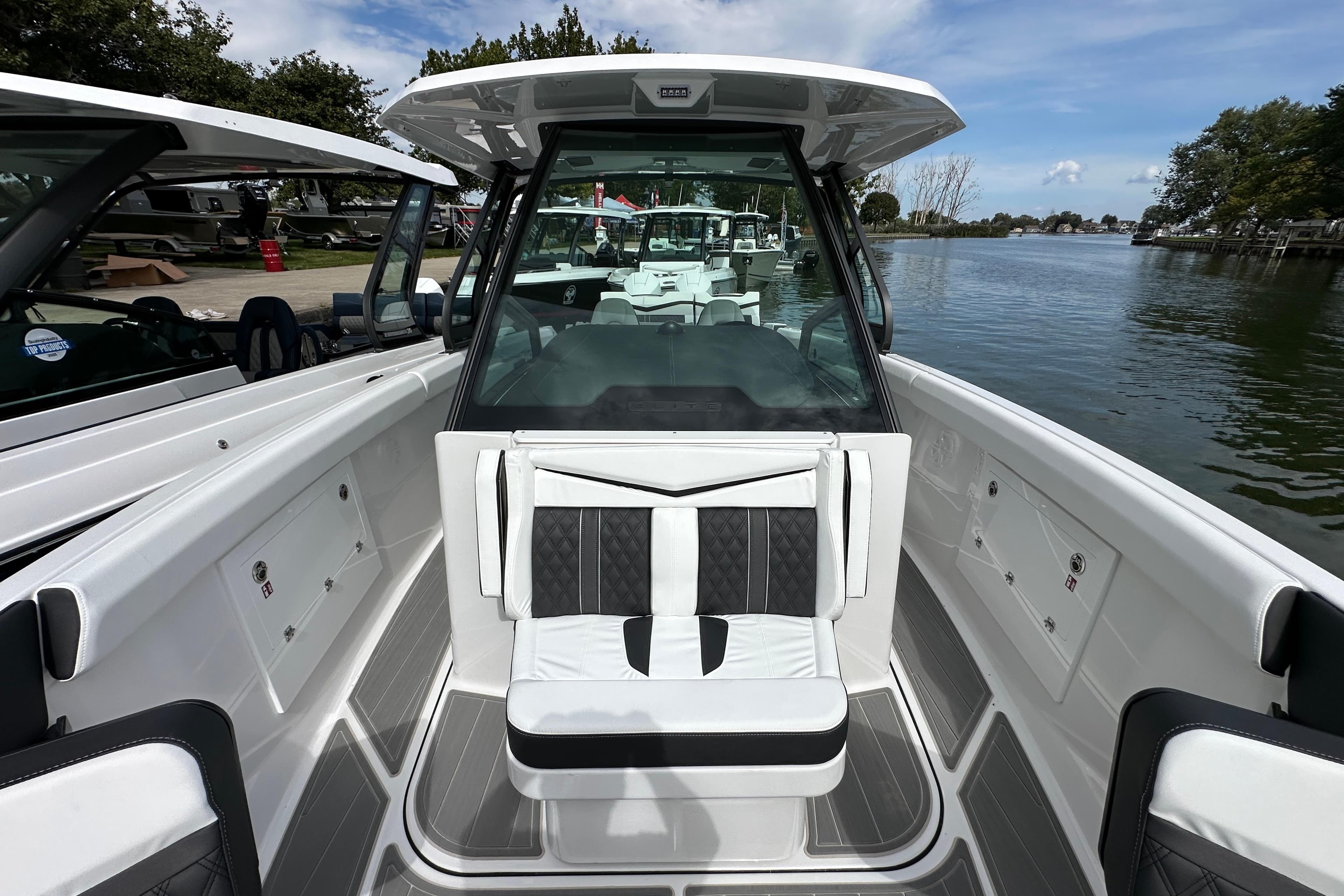 2026 Monterey Elite 30 OB boat interior with sleek seating and modern design on a calm waterway.