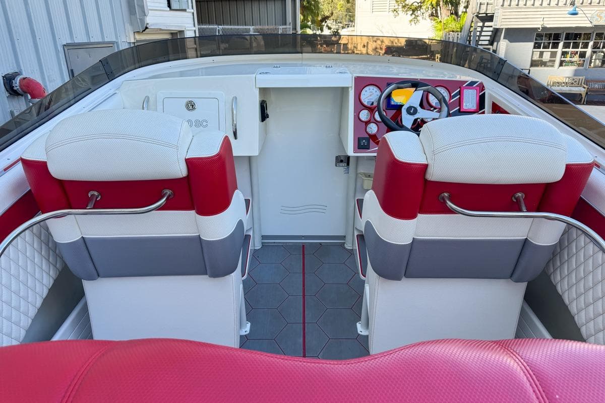 2022 Velocity 290sc boat interior with red and white seating, modern dashboard, and steering wheel.