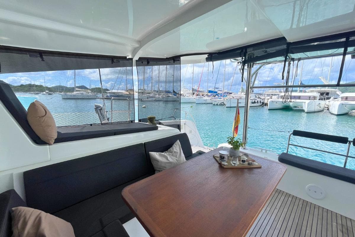 2018 Lagoon 42 catamaran interior with seating, table, and marina view.
