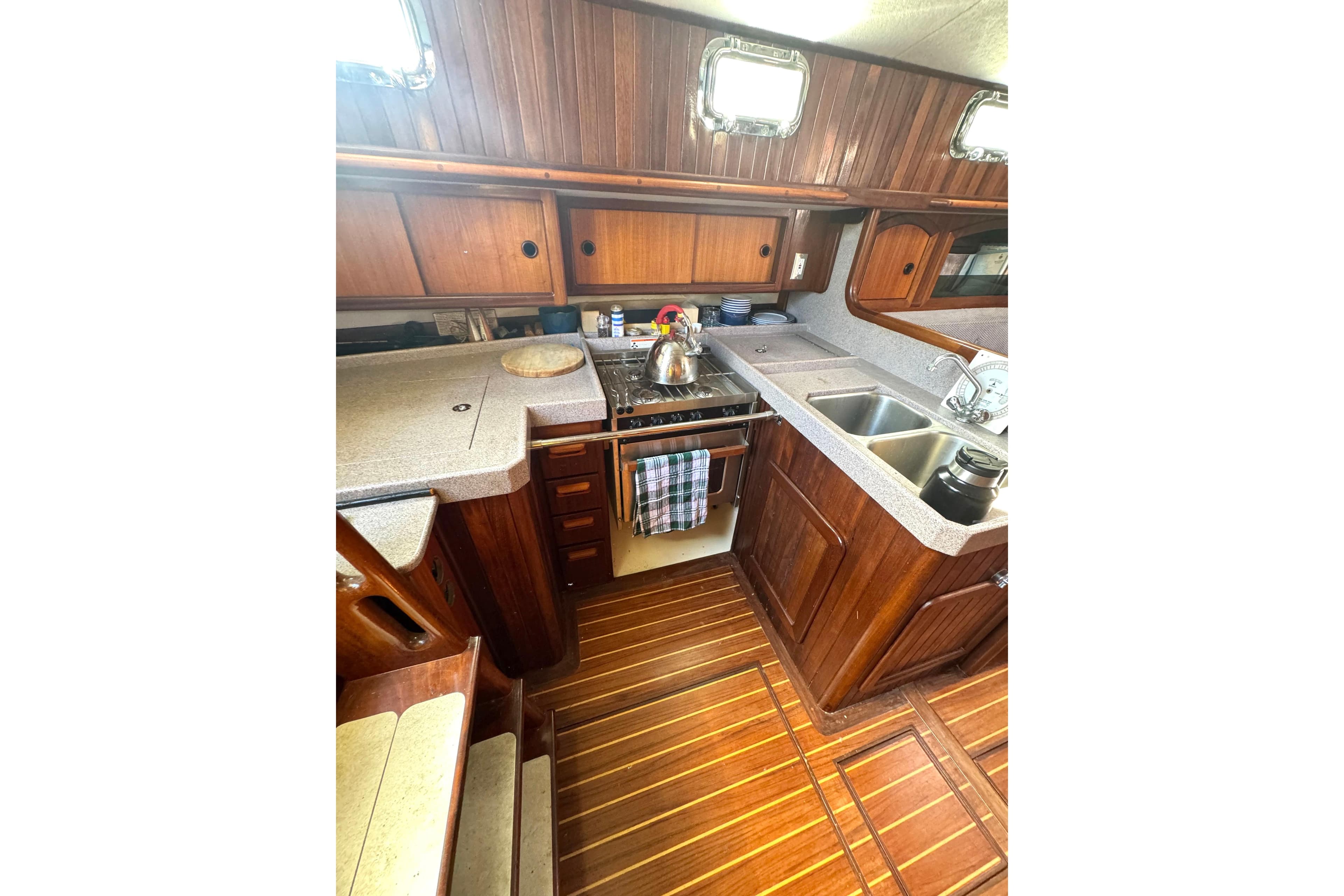 Wooden yacht kitchen interior with stove, sink, and storage; Custom Seawing-Atkins 2003 model.