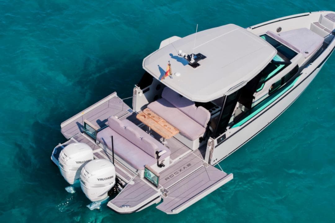 2023 Saxdor 320 GTO luxury boat on clear blue water, featuring twin Mercury engines.