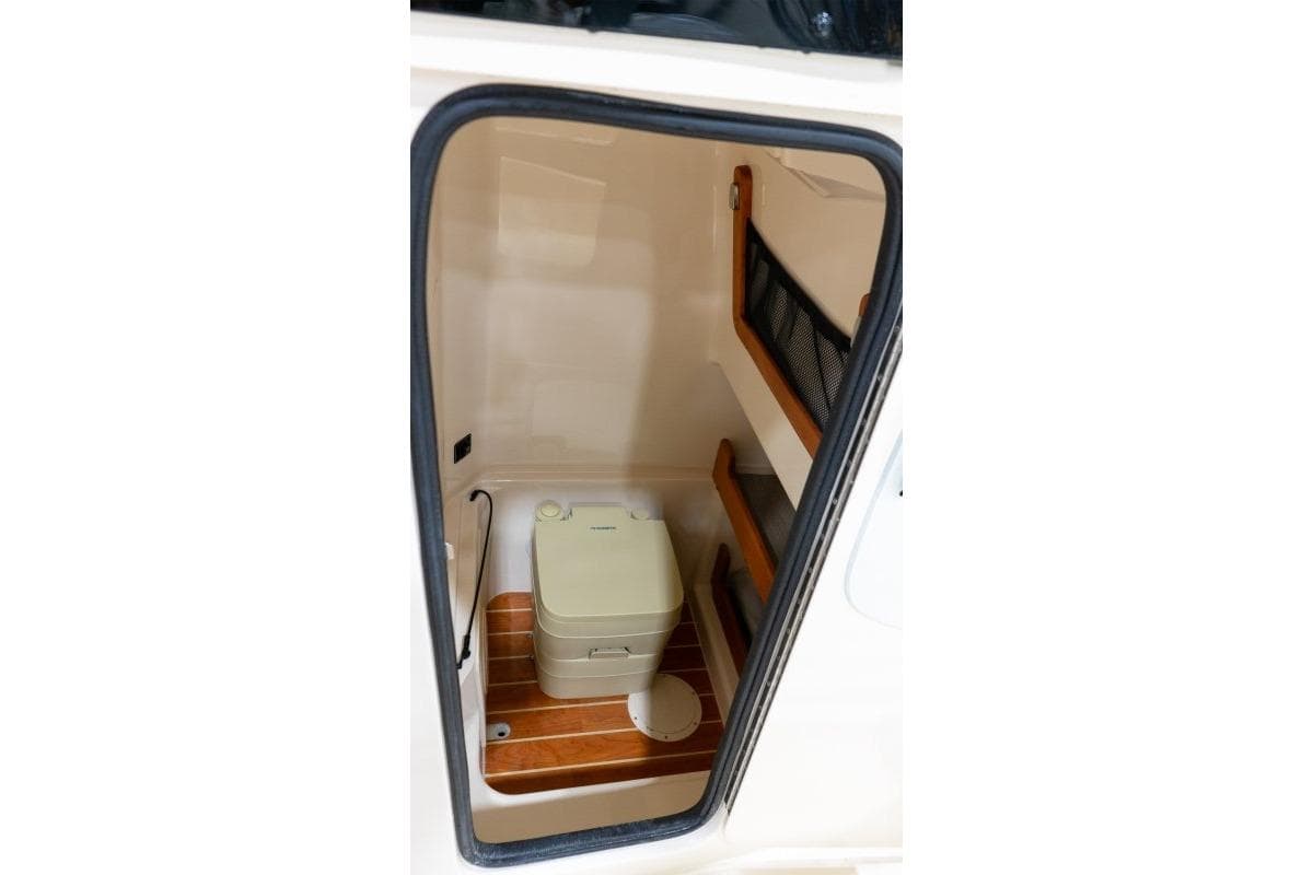 2025 Grady-White Fisherman 257 boat interior with compact toilet and storage.