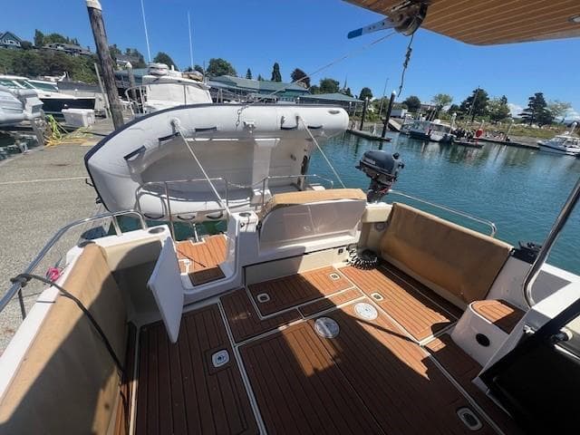 2022 Ranger Tugs R-29 S boat with spacious deck, docked at marina under clear blue sky.