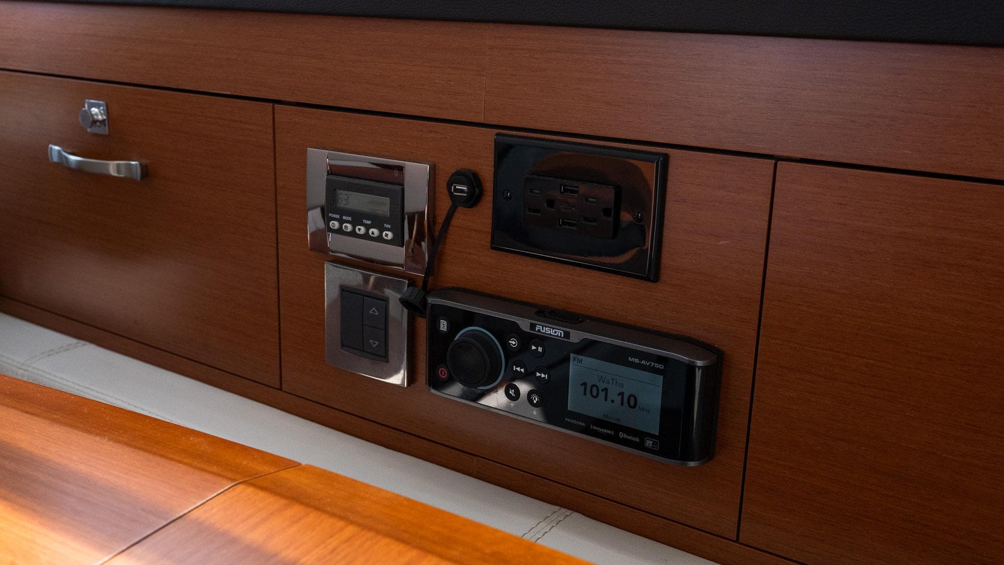 Control panel on 2018 Jeanneau NC11 yacht with wood finish and electronic displays.