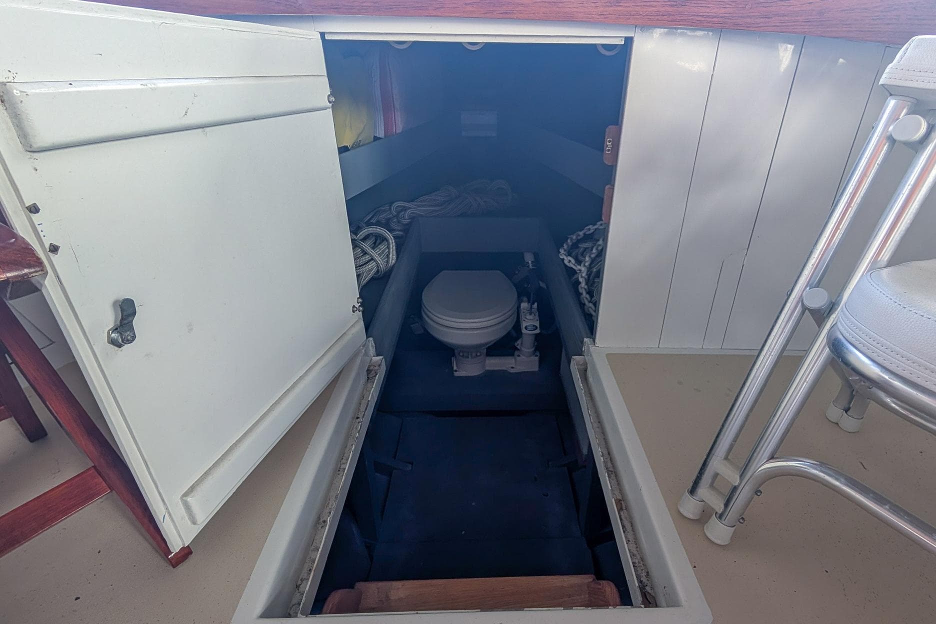 1954 Daniels Brothers model 28 boat interior with open storage compartment and visible toilet.