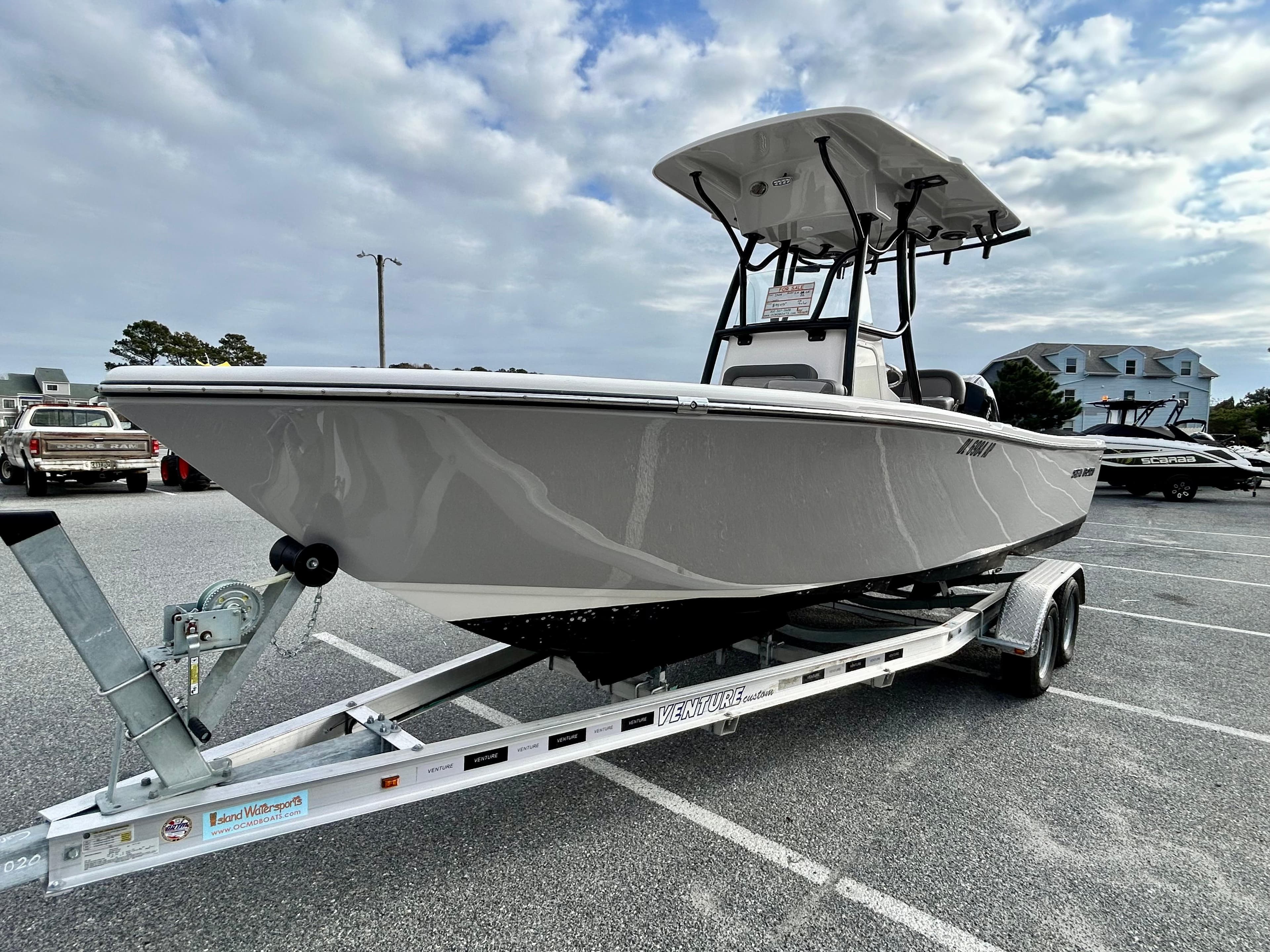 2024 Sea Born LX 22 LE boat on trailer, parked outdoors under cloudy sky.