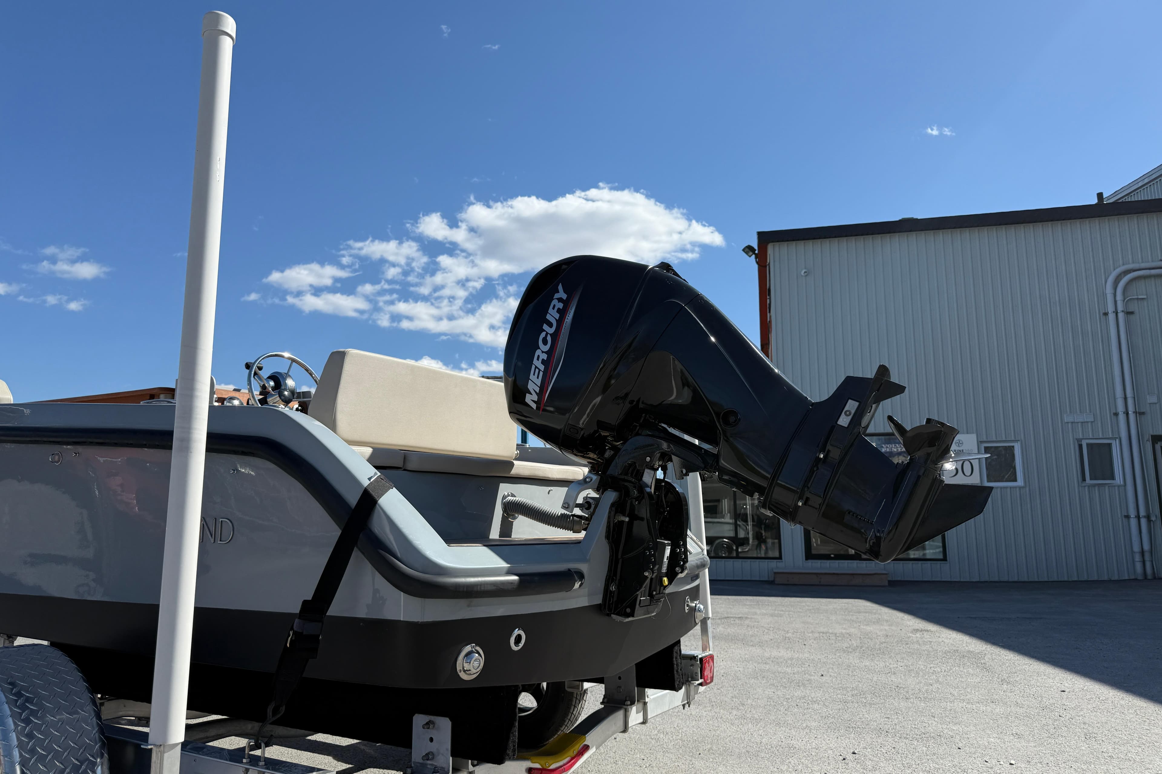 2018 Rand Picnic 18 boat with Mercury outboard motor, parked outdoors under clear sky.