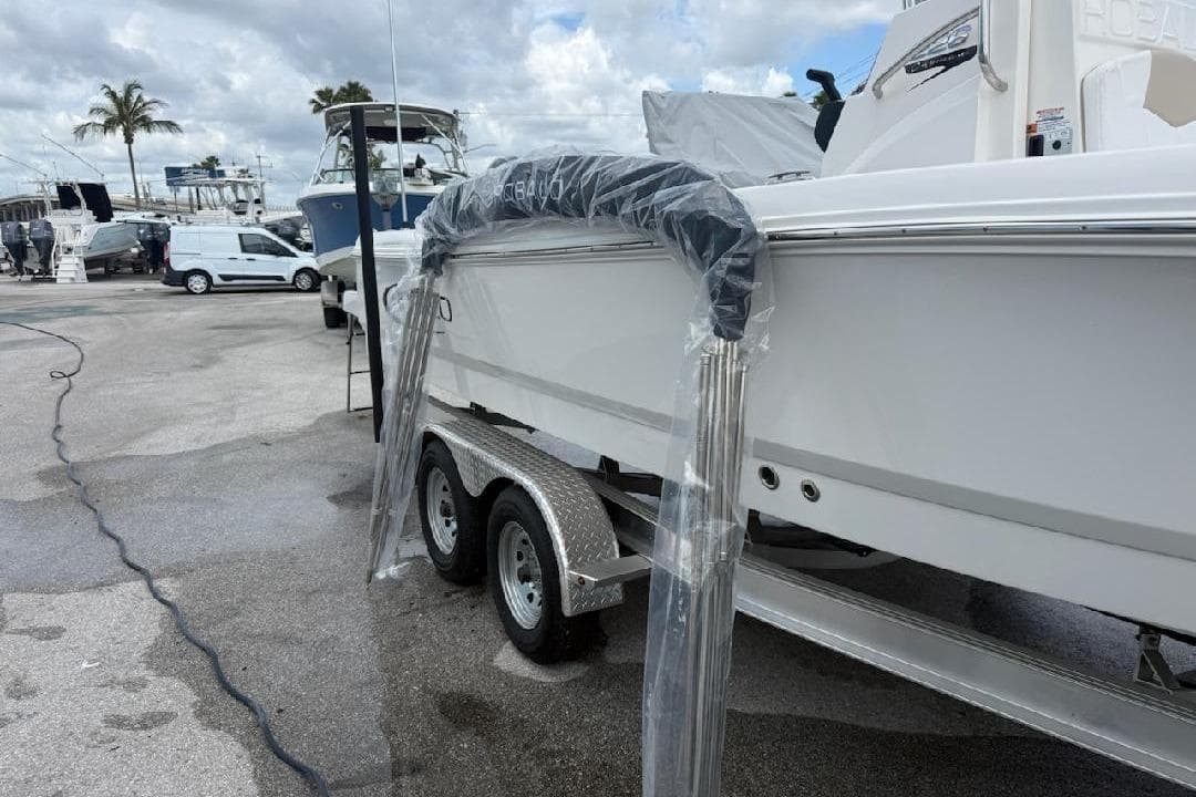 2026 Robalo 226 Cayman boat on trailer, marina background, cloudy sky.