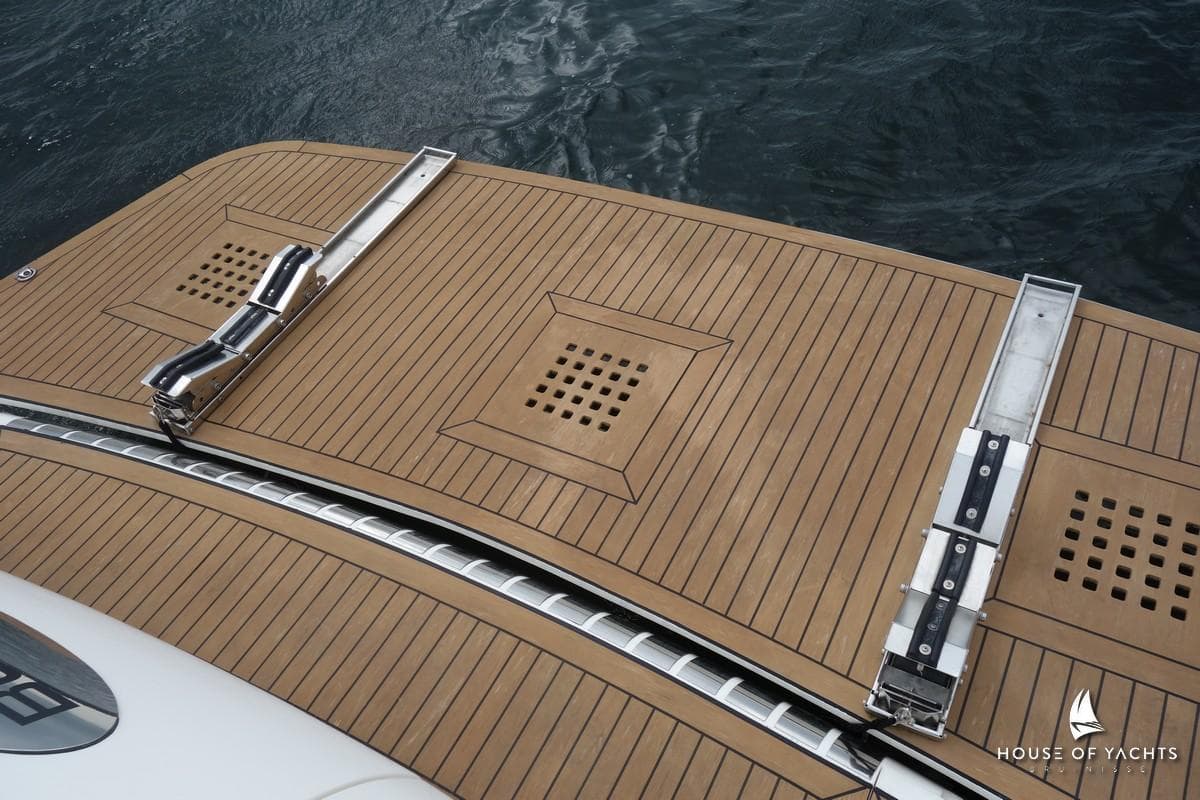 Teak deck of 1996 Princess V52 yacht with metal fittings, near water.