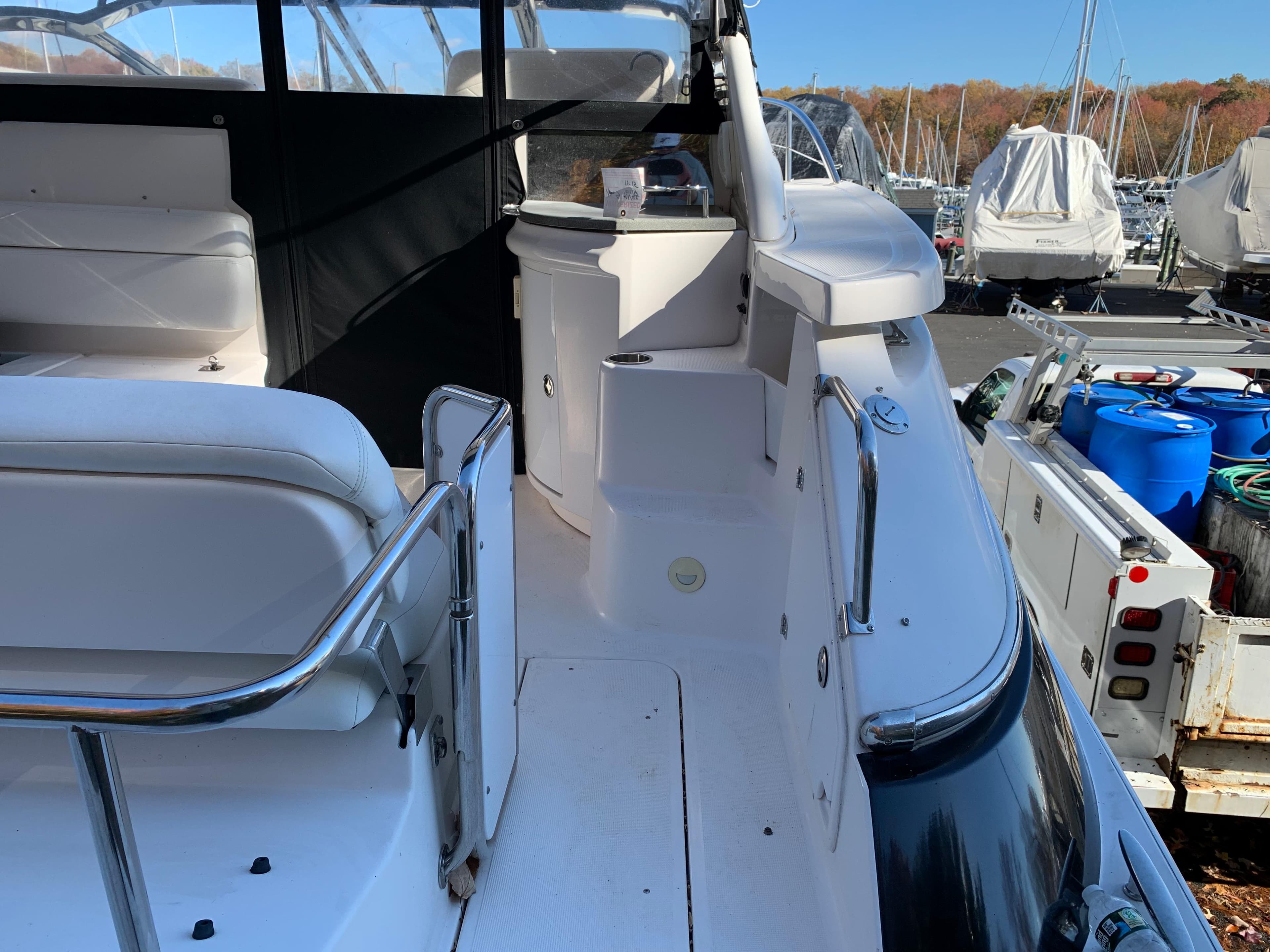 2009 Regal 4460 yacht interior with white seating and docked boats in background.