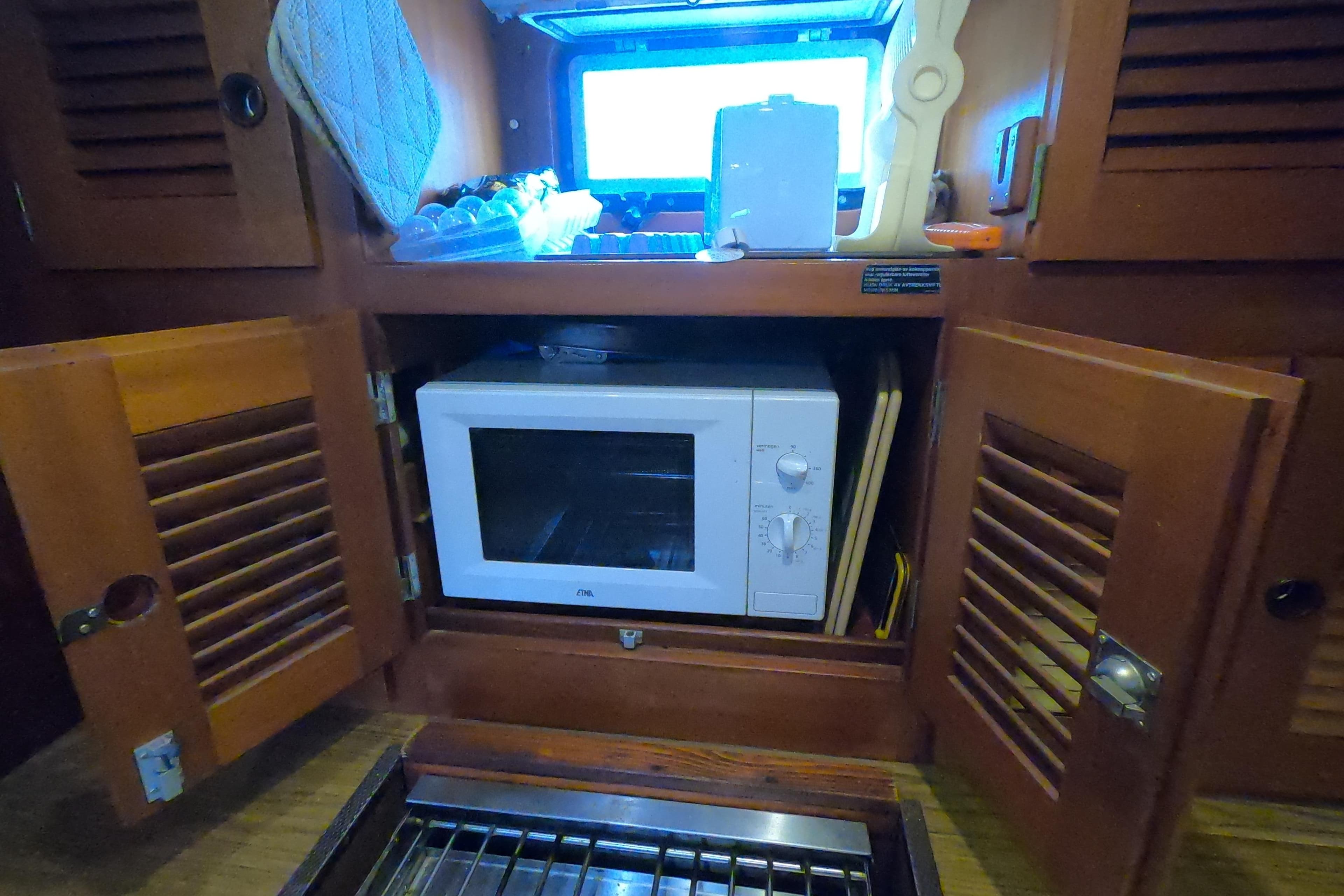 Microwave in wooden cabinet on 1986 Hallberg-Rassy 49 yacht kitchen.
