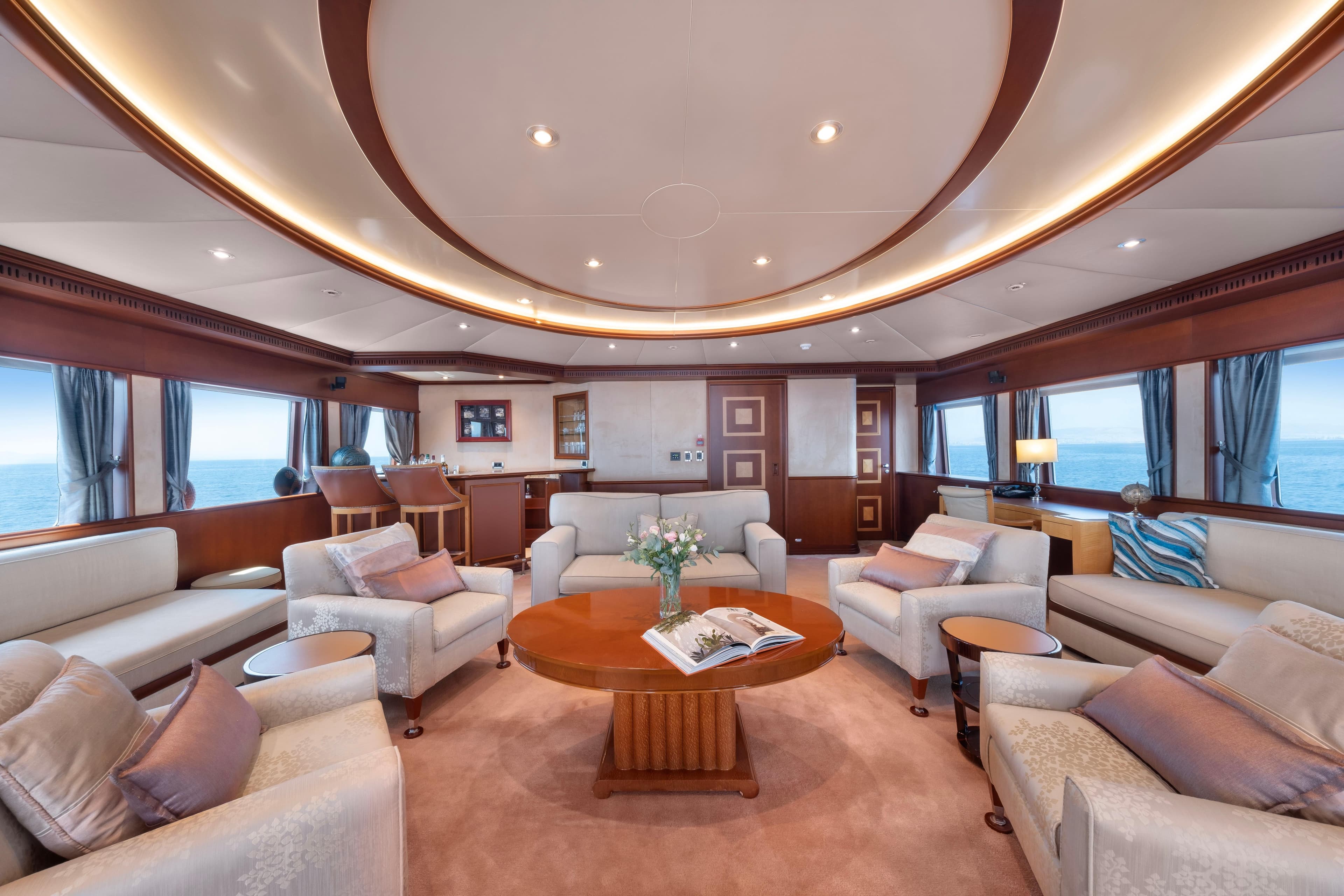 Luxurious yacht interior with elegant seating, wooden accents, and ocean views, R.B Dereli 2004 model.