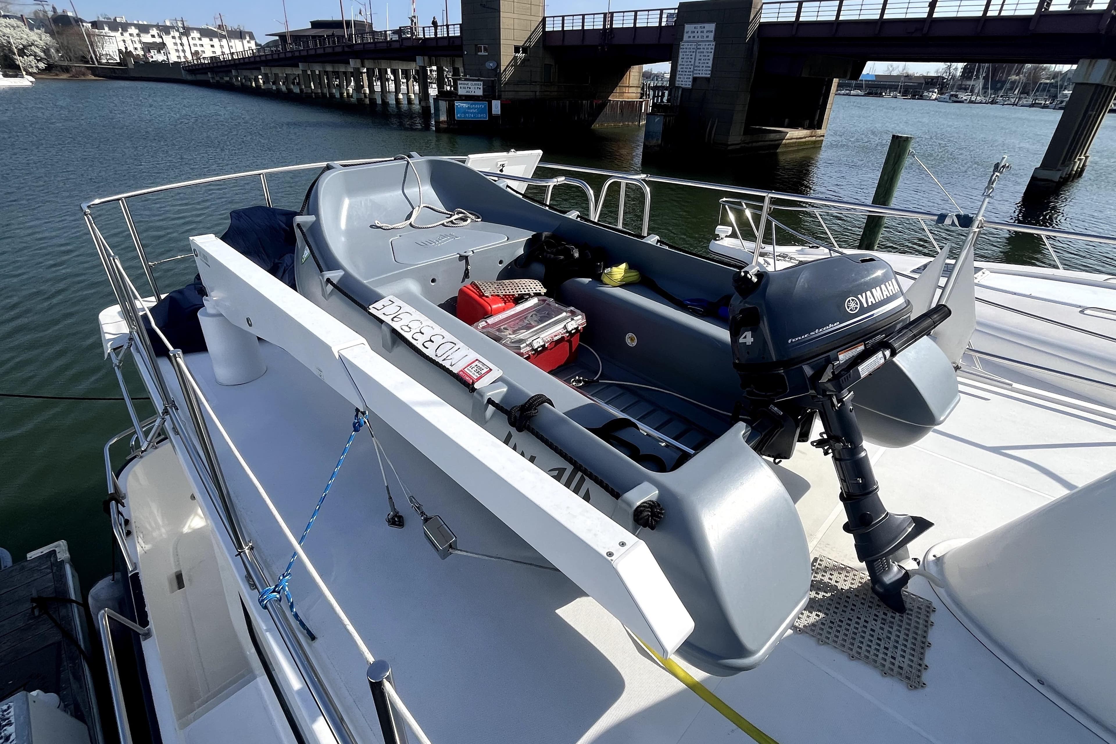 2008 Nordic Tug 42 with Yamaha motorboat on deck, docked near a bridge.