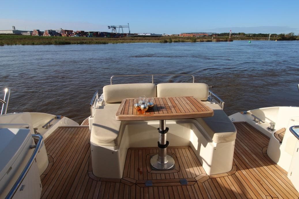Luxury yacht deck with seating and table, Atlantis 50x4, 2009 model, overlooking serene waters.