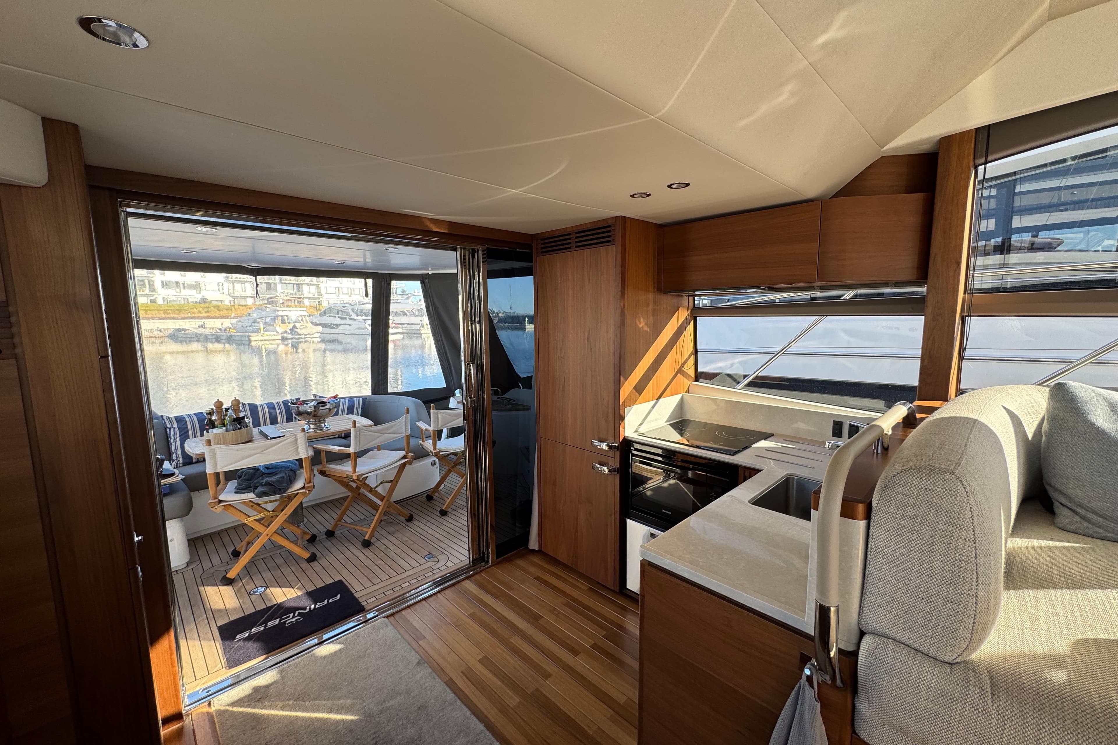 Luxurious interior of 2020 Princess F50 yacht with modern kitchen and outdoor seating area.