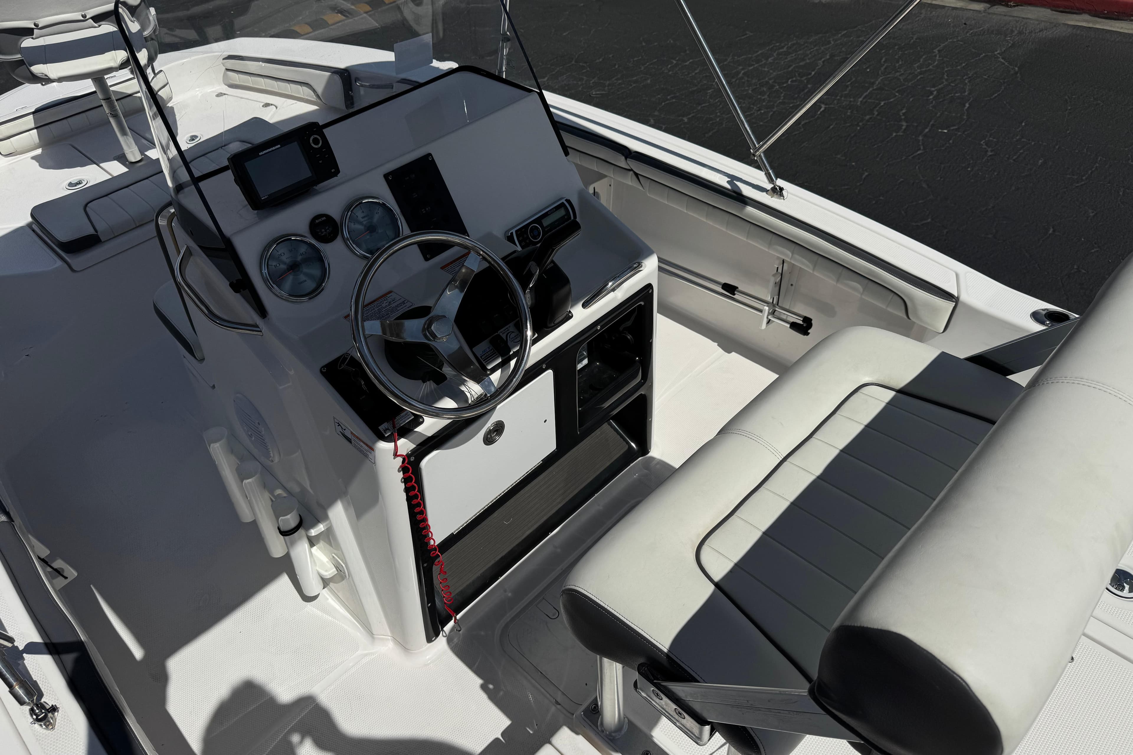 2016 Yamaha Boats 190 FSH Deluxe cockpit with steering wheel and seating.