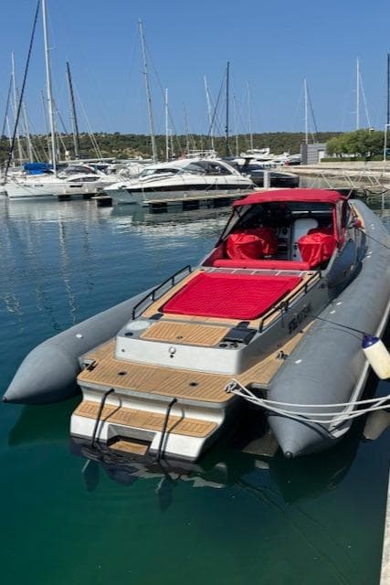 2008 FB Design Buzzi Rib 42 boat docked in marina with red seating.