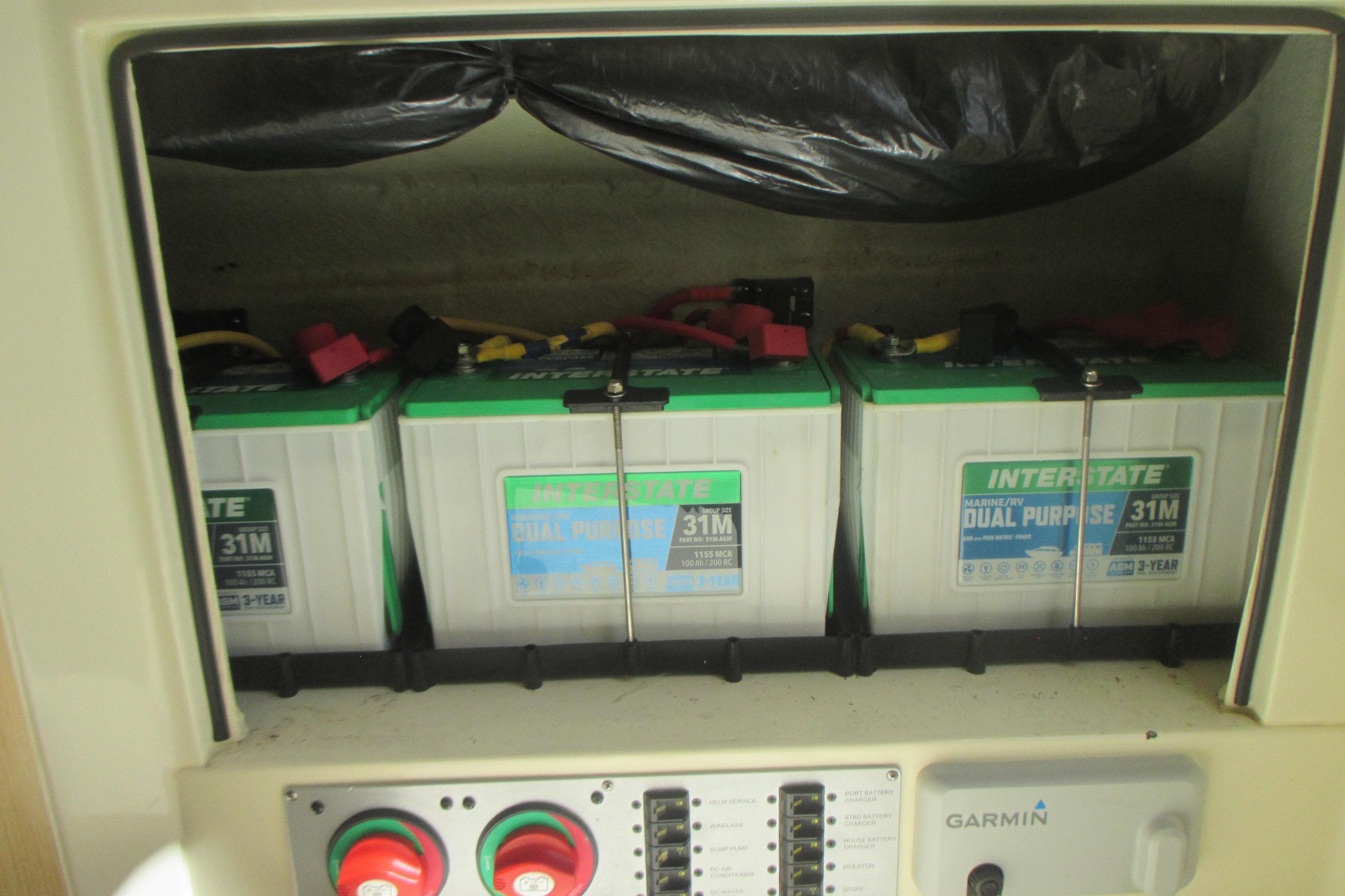 Three Interstate marine batteries in a 2019 Chris-Craft Catalina 30 boat compartment.