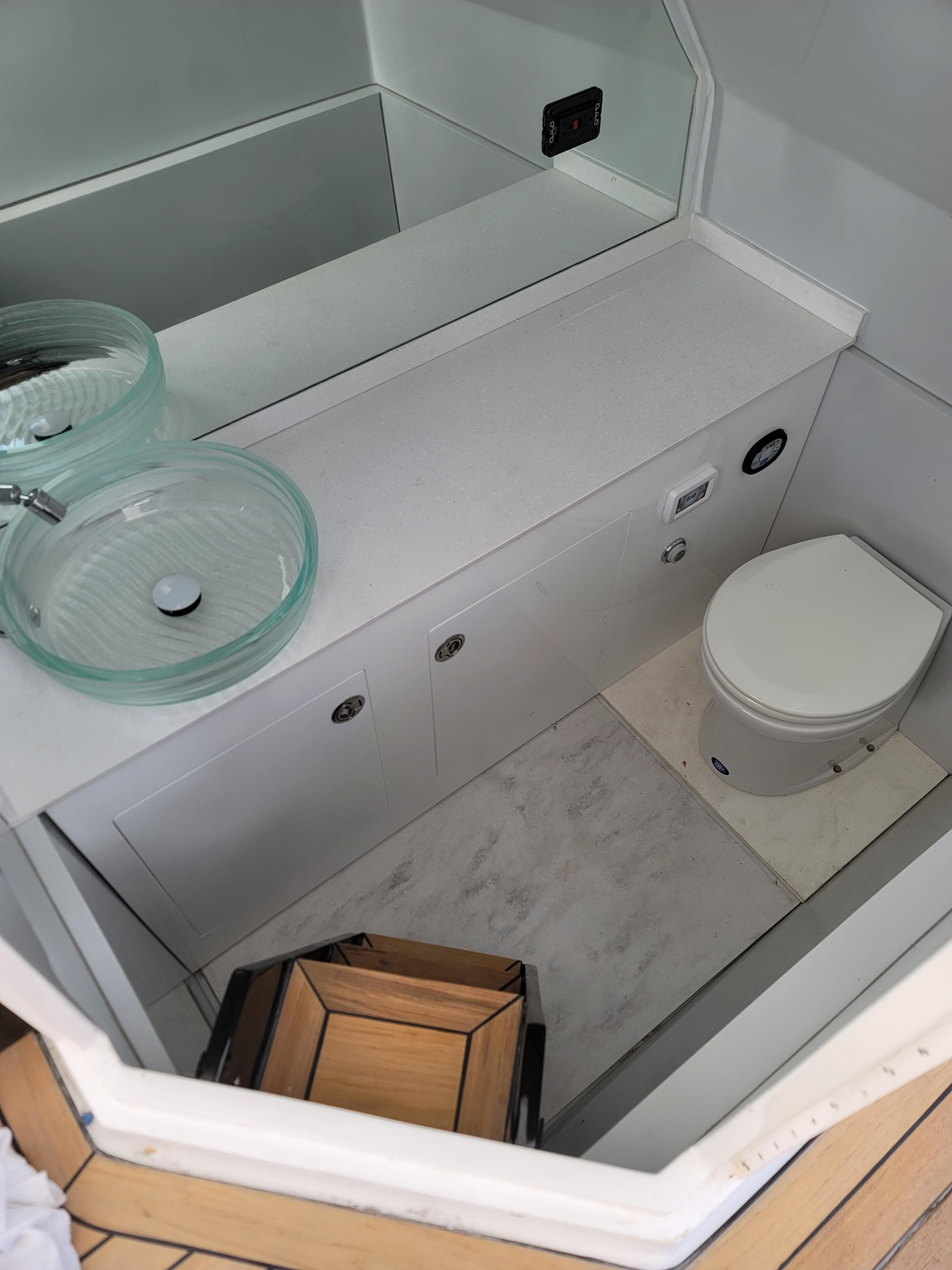Modern bathroom in 2022 Catamaran PRJ Cat40 with glass sink and compact toilet.